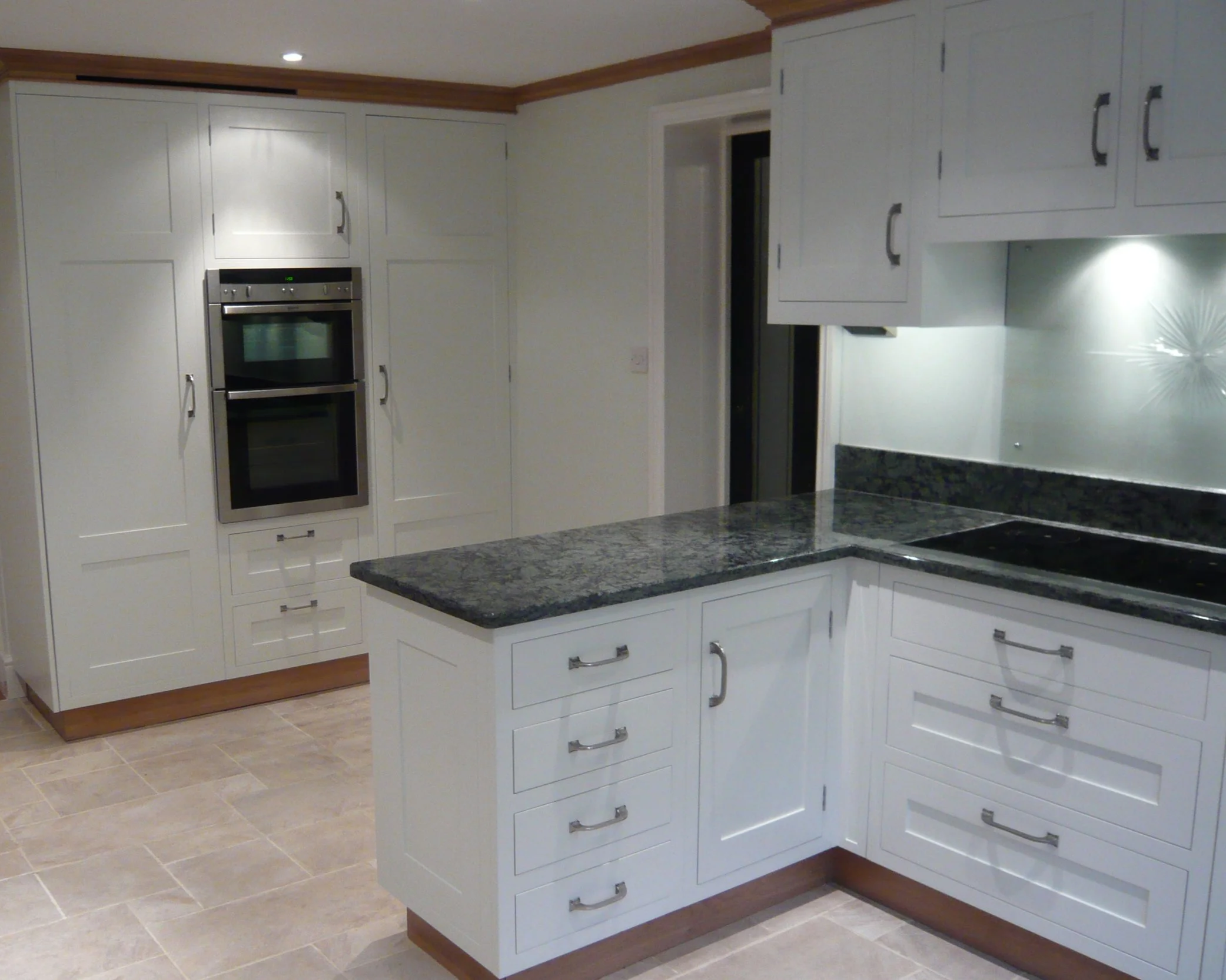 Traditional white painted kitchen with built in oven and pantry storage cupboards