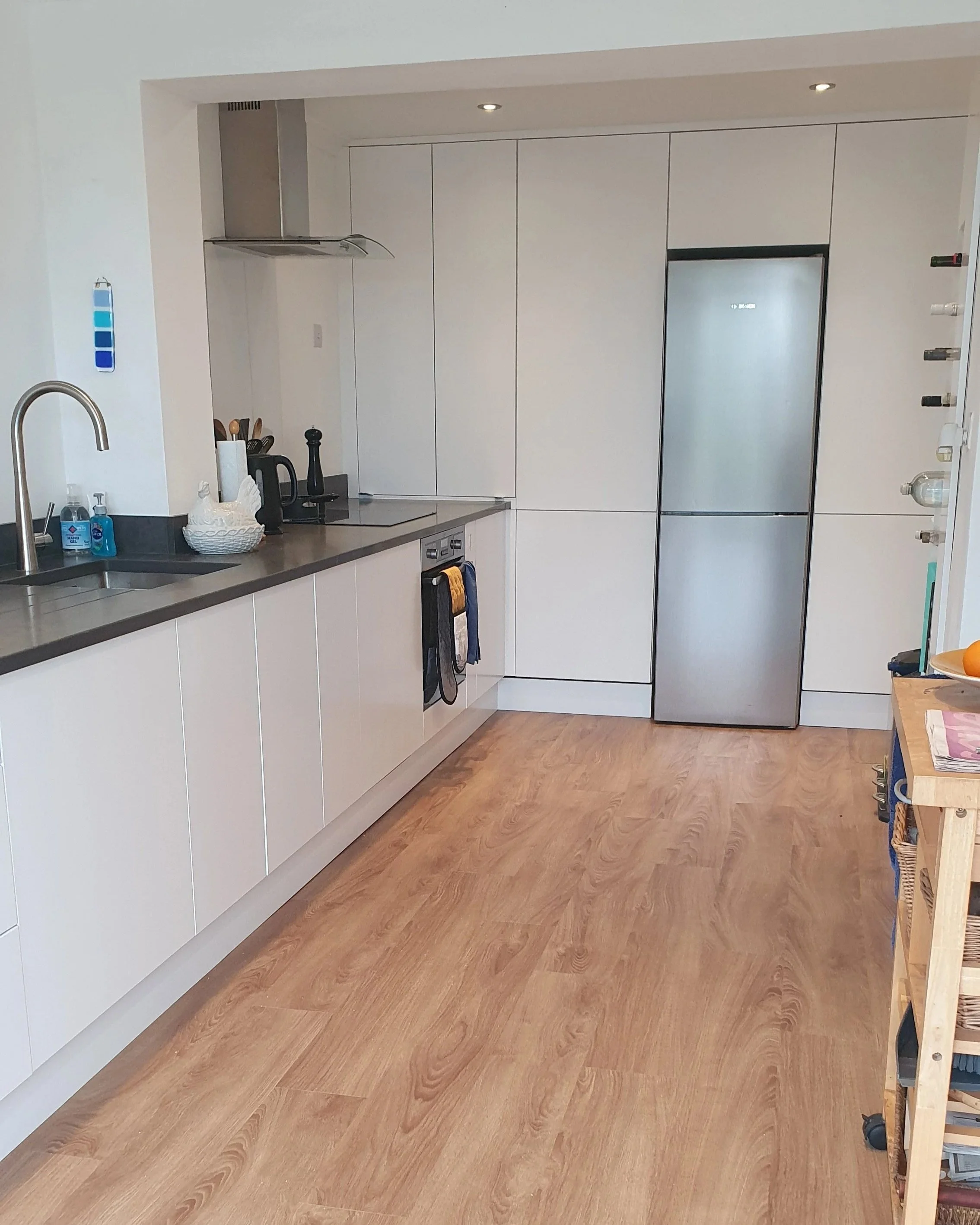 Modern white kitchen with floor to ceiling units 