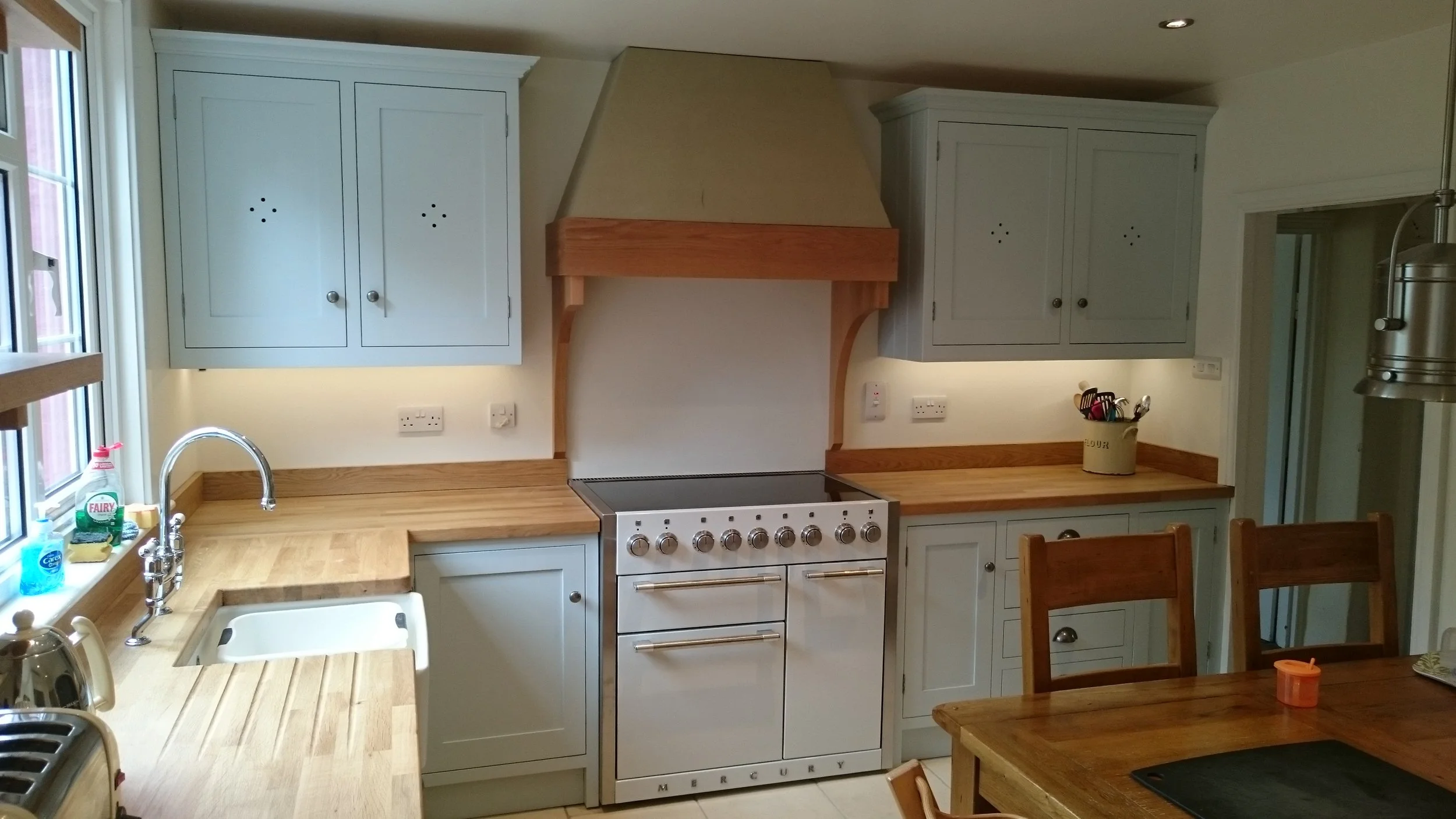 Hand painted duck egg blue farmhouse style kitchen with cream range cooker, traditional butler sink and Oak worktops