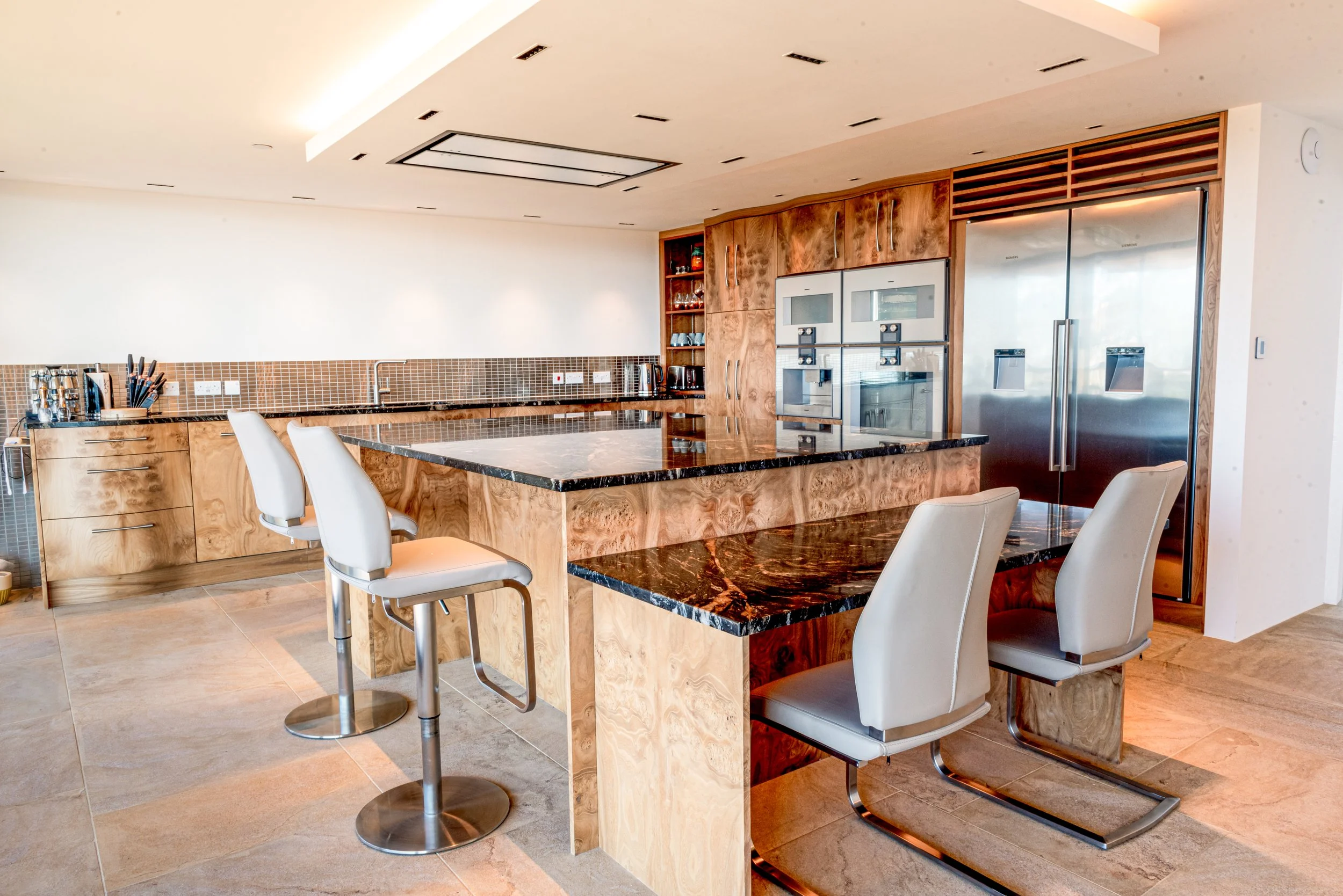 Stunning contemporary curved kitchen units made from Burr Elm veneer 