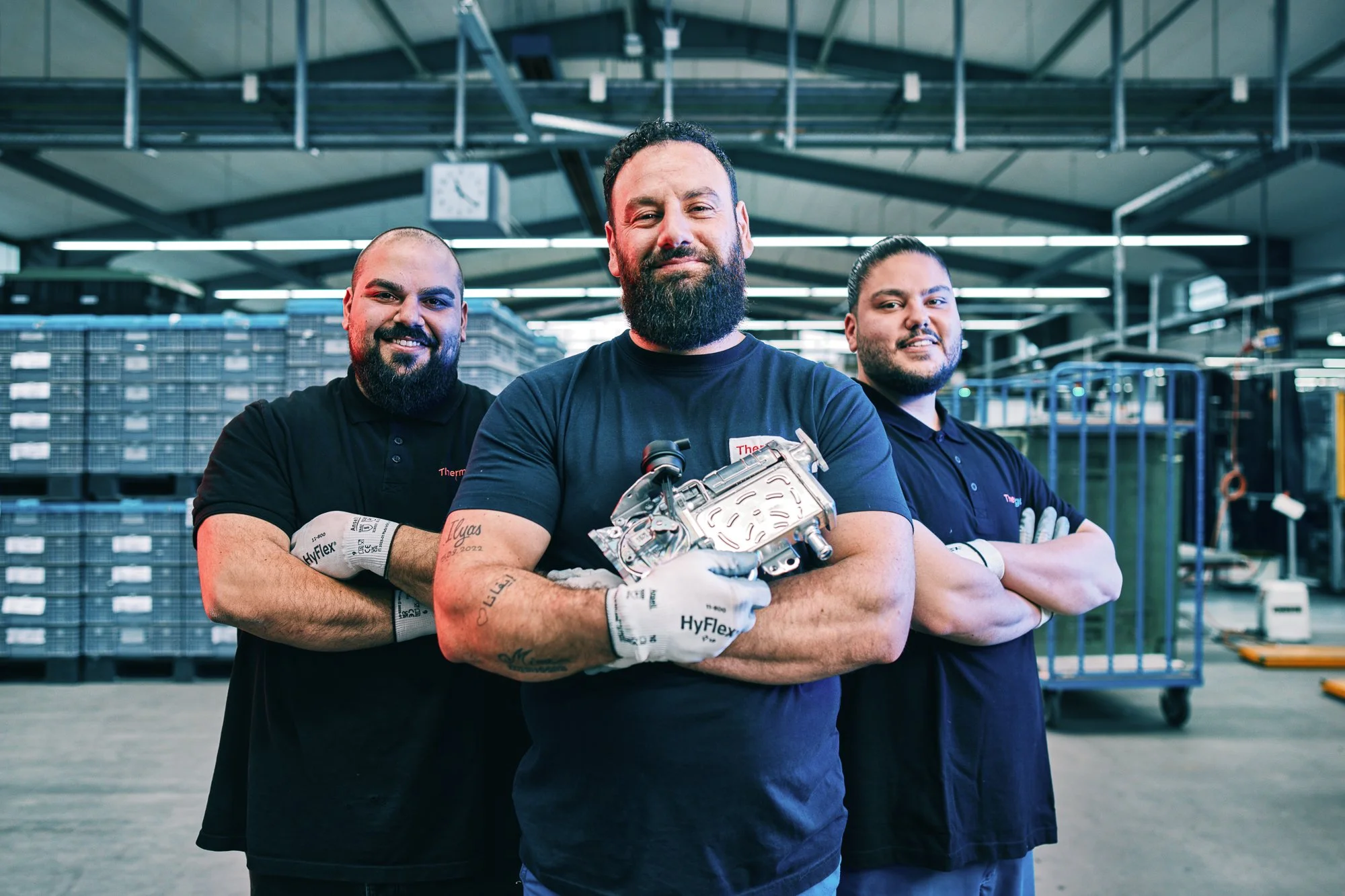 Thermagenix Produktionsteam in der Fertigung von Wärmetauschern – Mitarbeiter präsentieren montiertes Bauteil