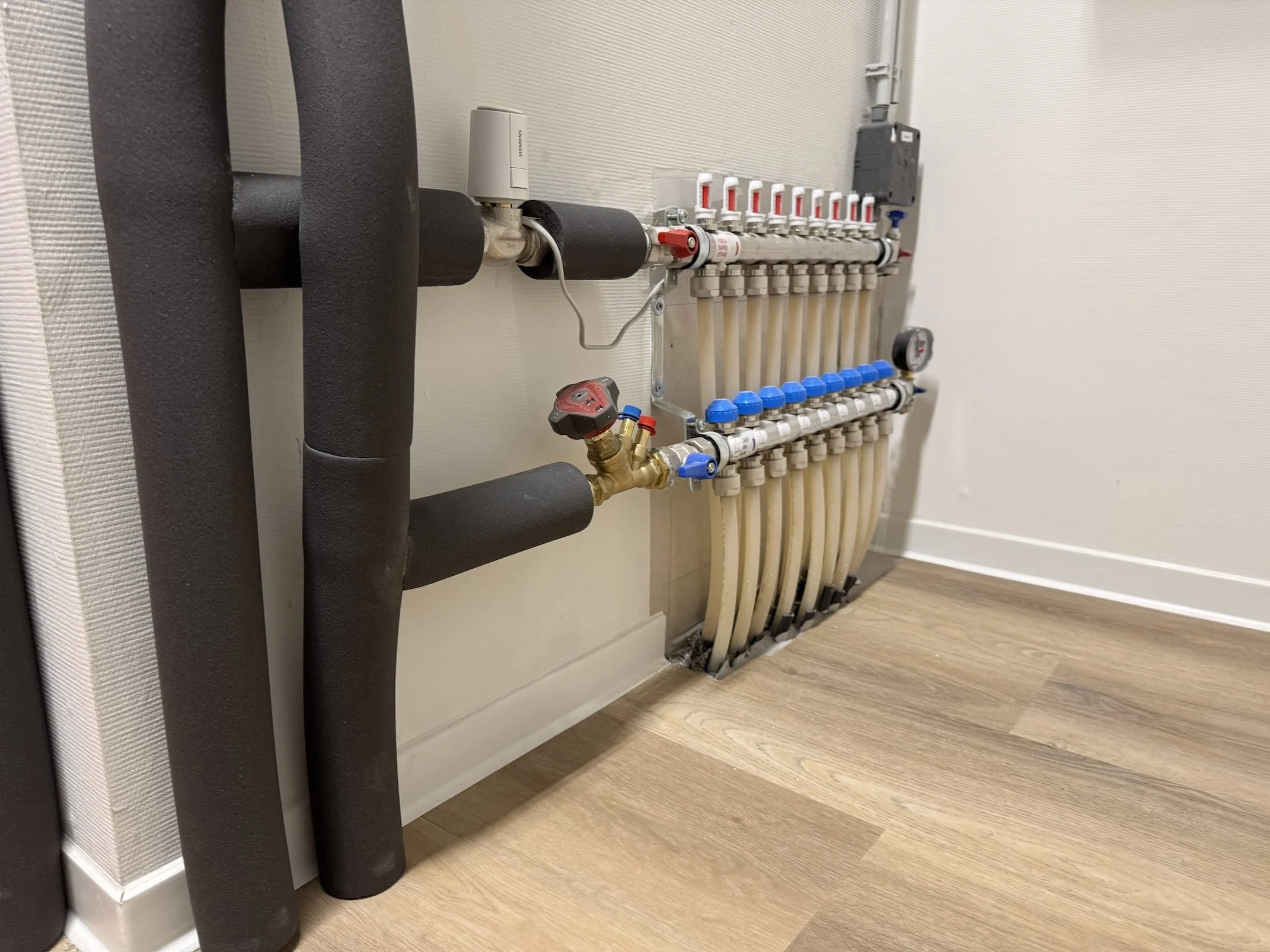 Warmte- en koudwaterleidingen met verdeel- en regelapparatuur in een gebouw.