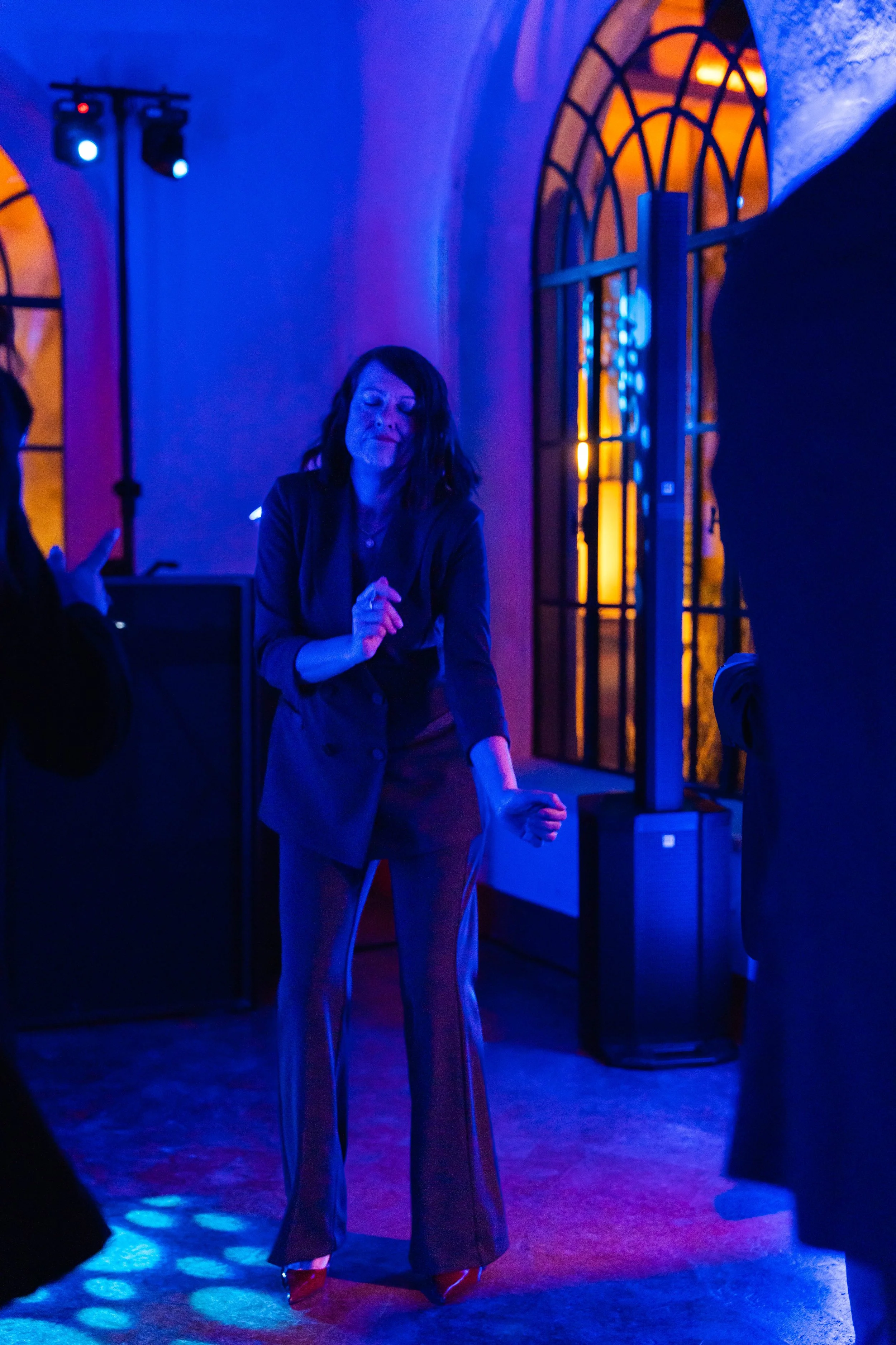 Donna che balla in un locale con luci soffuse di colore blu e arancione.