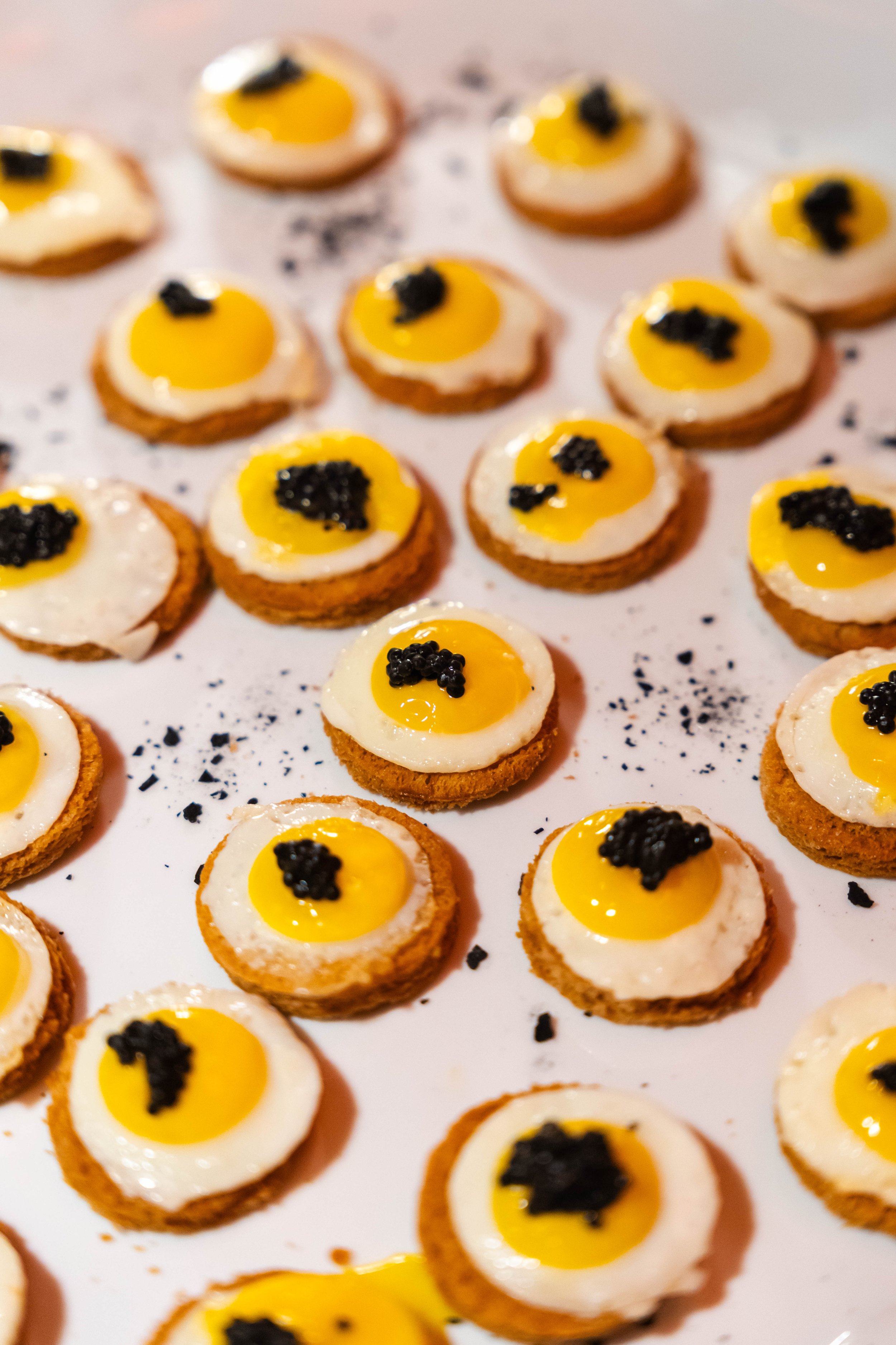 Piccoli dolcetti decorati come uova di Pasqua con un tuorlo giallo e cotto, decorati con un tocco di nero
