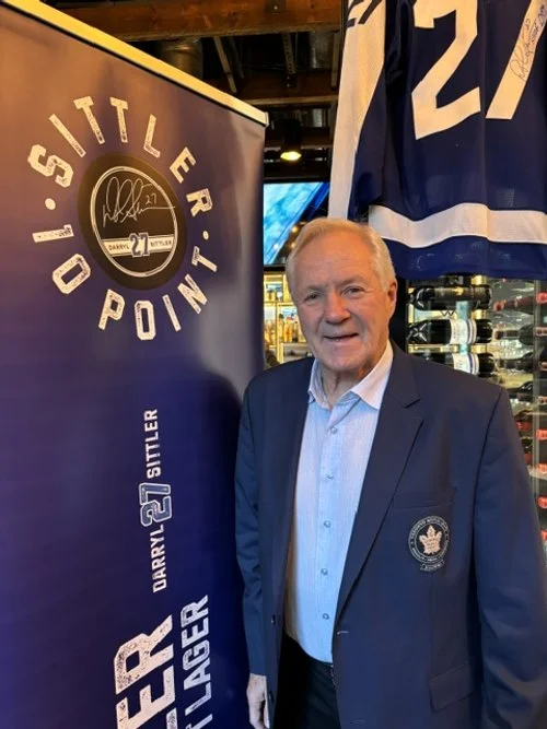 Toronto Maple Leafs logo stands next to a banner that says '1st Little Tip' and features Darryl Sittler's signature and number 27. He's smiling and appears to be at a sports bar or pub with jerseys and bottles in the background.
