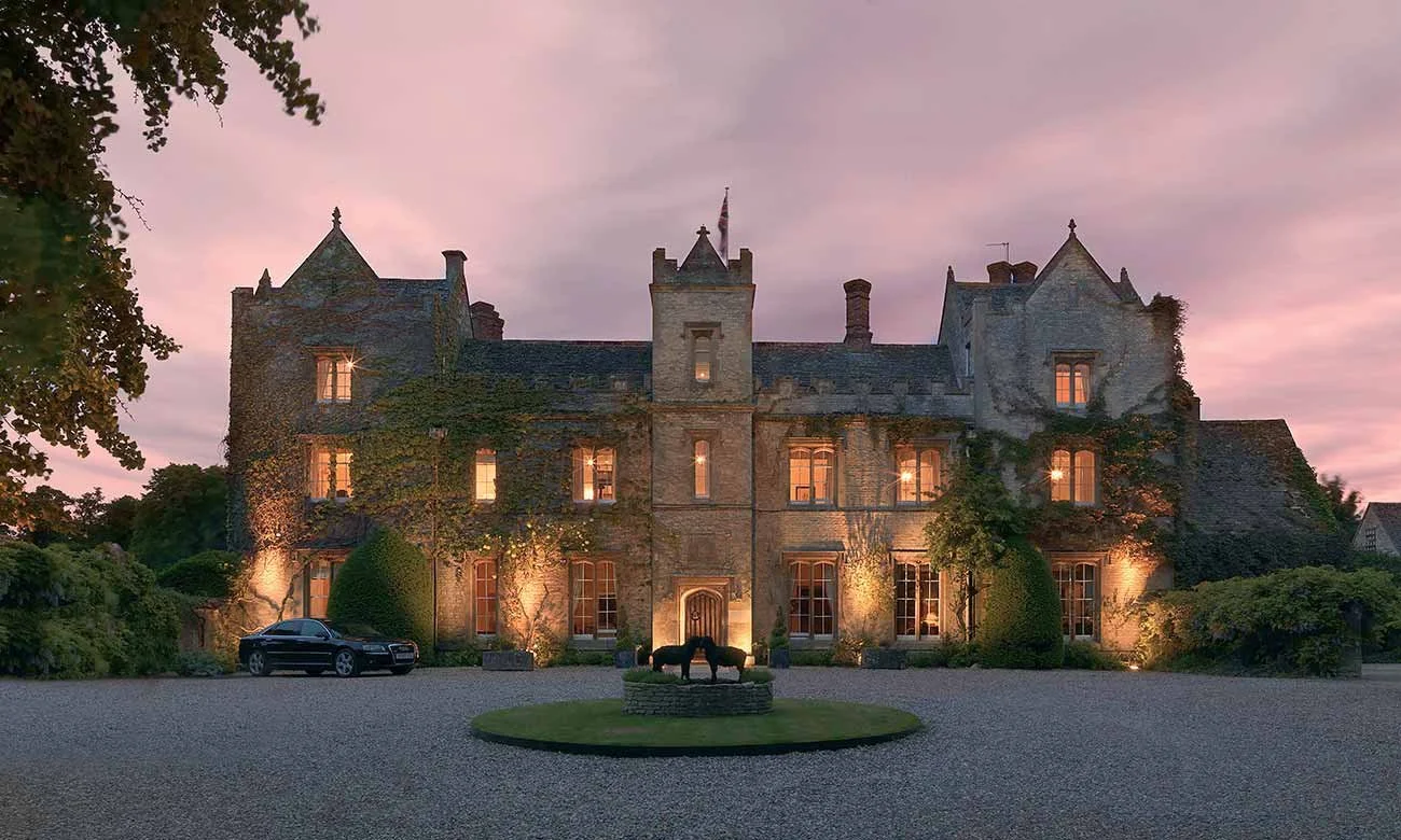 Ravenhoolt Manor website redesign by Gather Studio — stone castle with fountain and horse statues at sunset