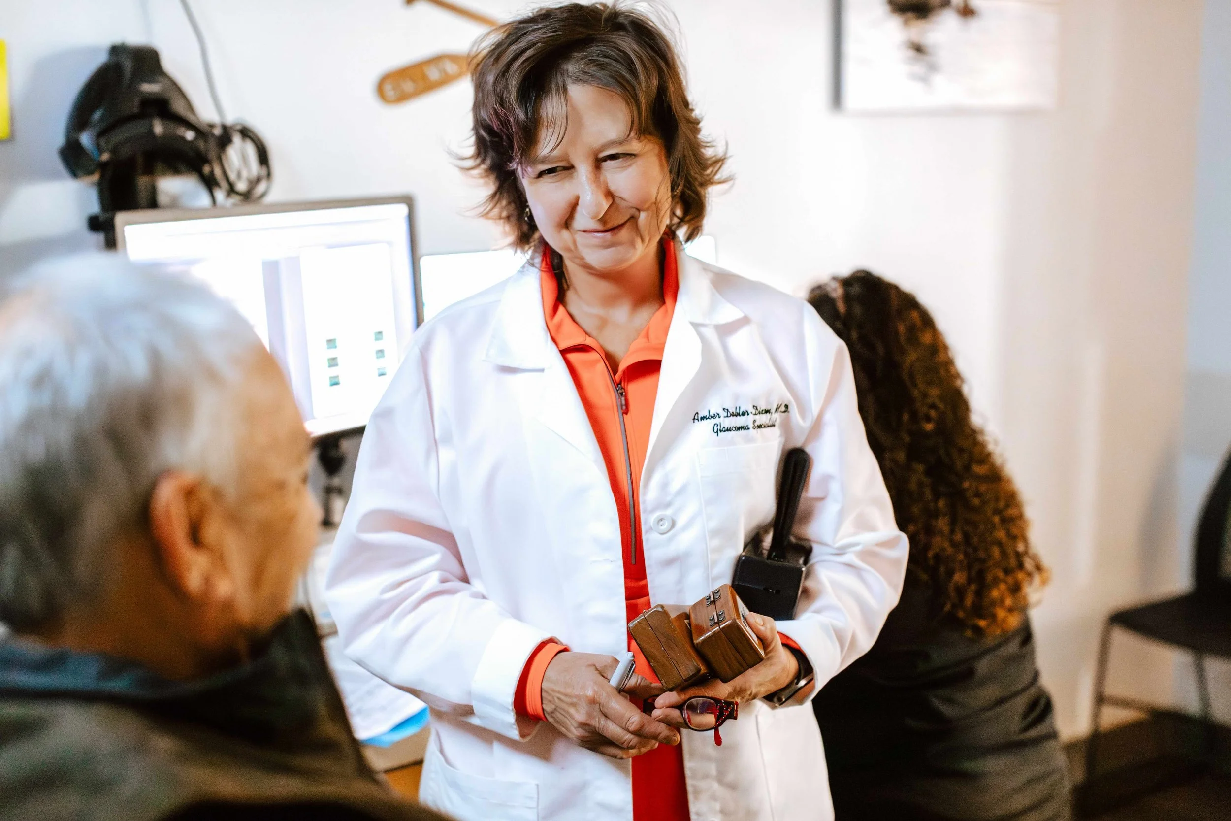 Dr. Dobler-Dixon in a white doctor's coat talking to a patient