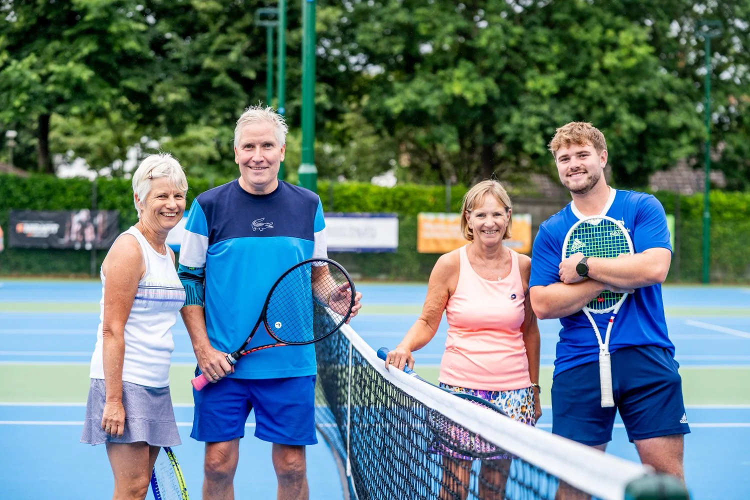 4 tennis players stood at the net