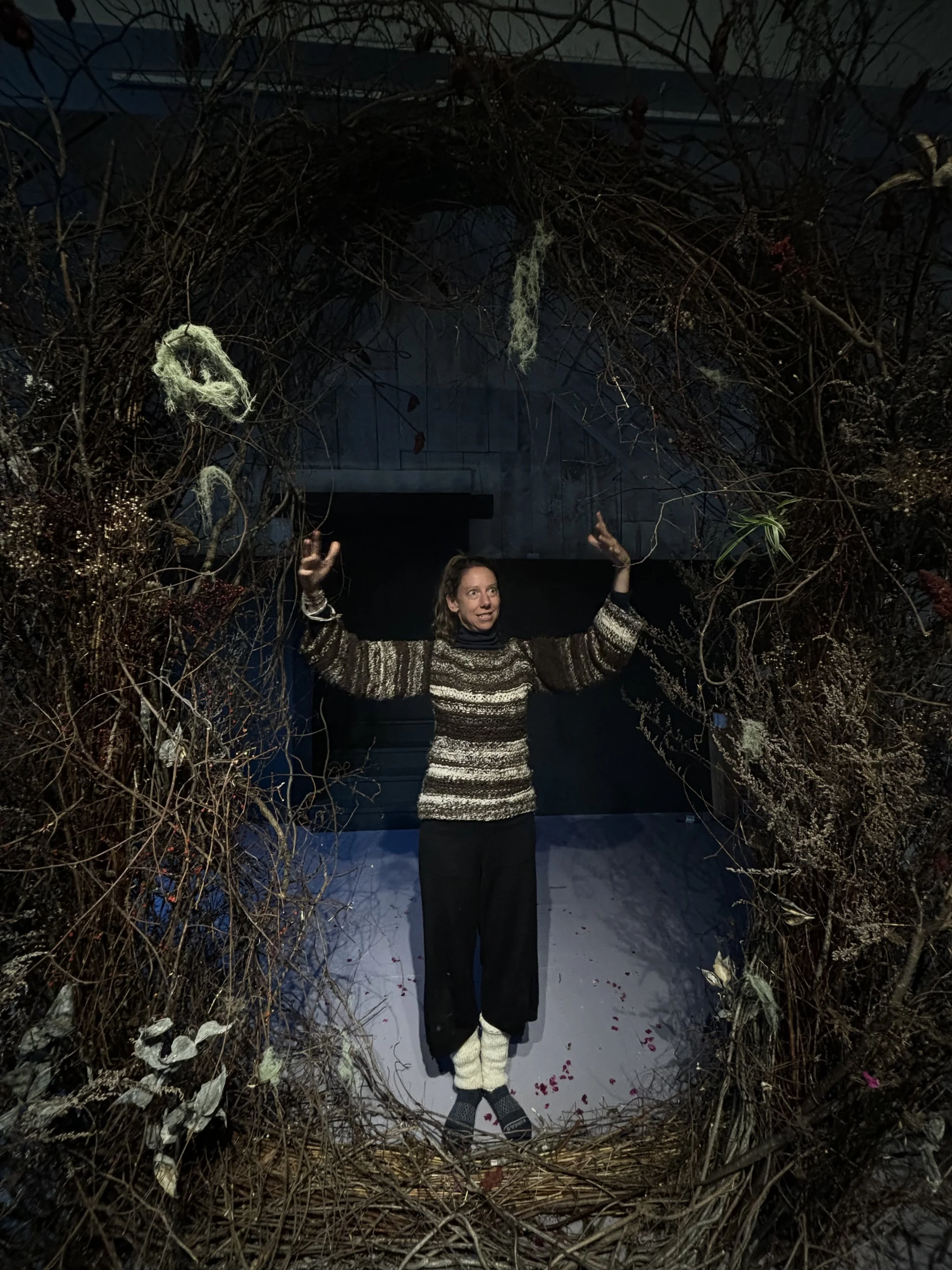 Heather Lyon standing in plant portal sculpture with arms outstretched