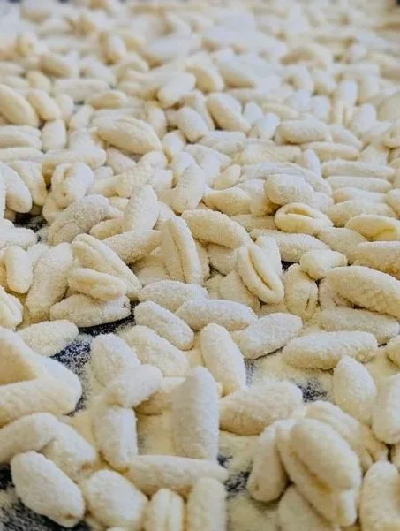 Dried homemade pasta noodles on a black surface.