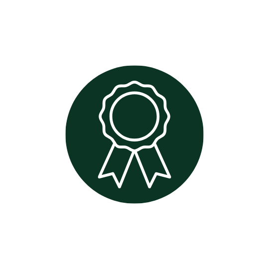 Icon of a white award or ribbon badge on a dark green circular background.