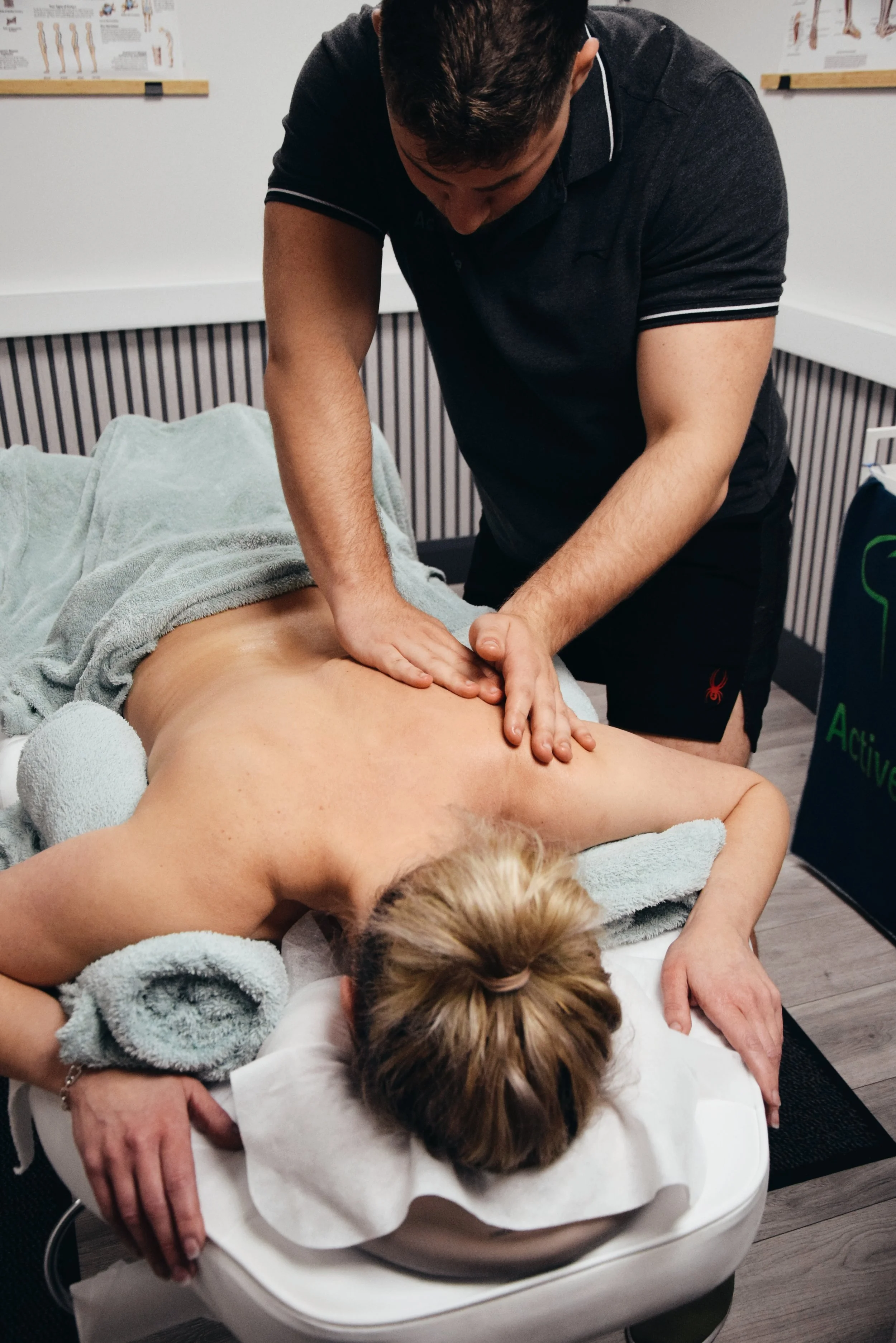 A person receiving a back massage from a therapist in a clinic or massage room.