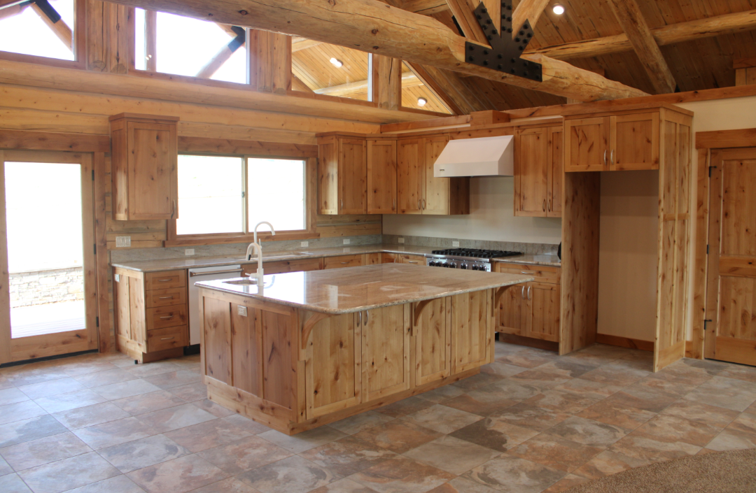 Wooden kitchen with island, cabinets, and a stove with a white range hood.