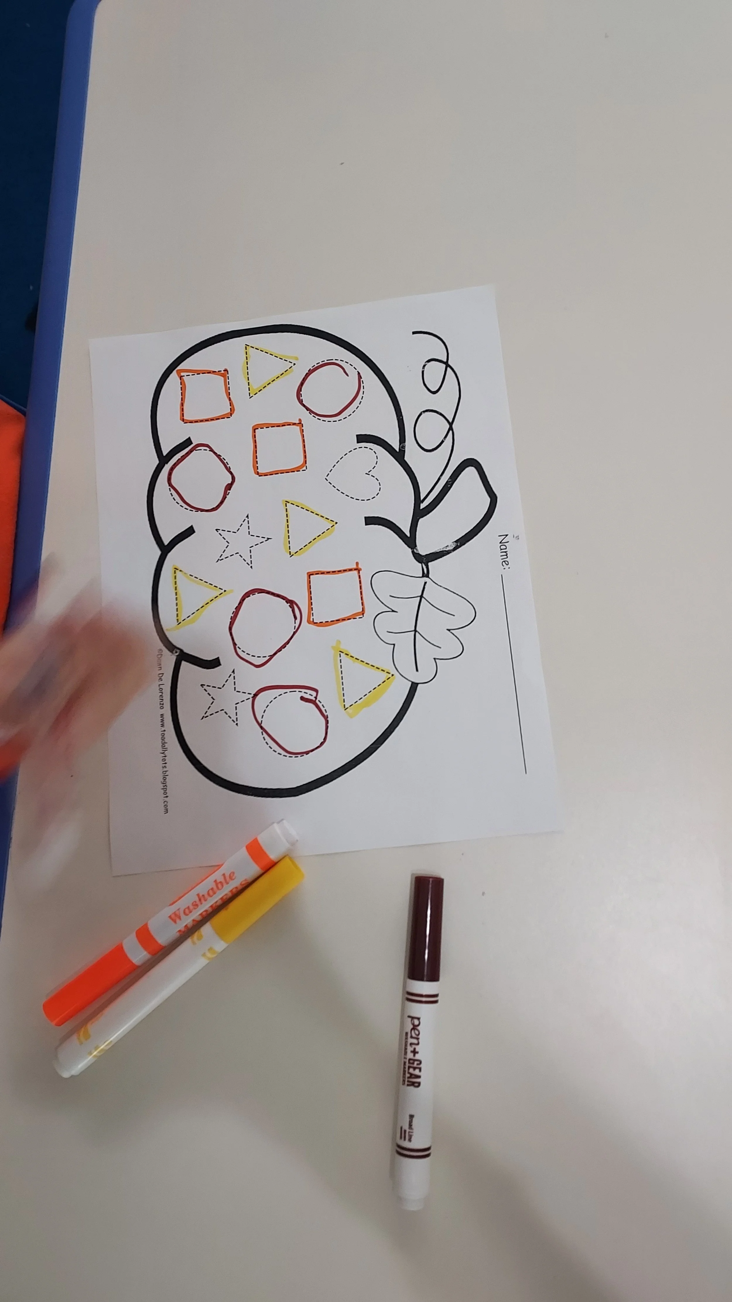 Coloring worksheet with a pumpkin outline, featuring various shapes inside, such as hearts, stars, circles, squares, and triangles, ready to be colored.