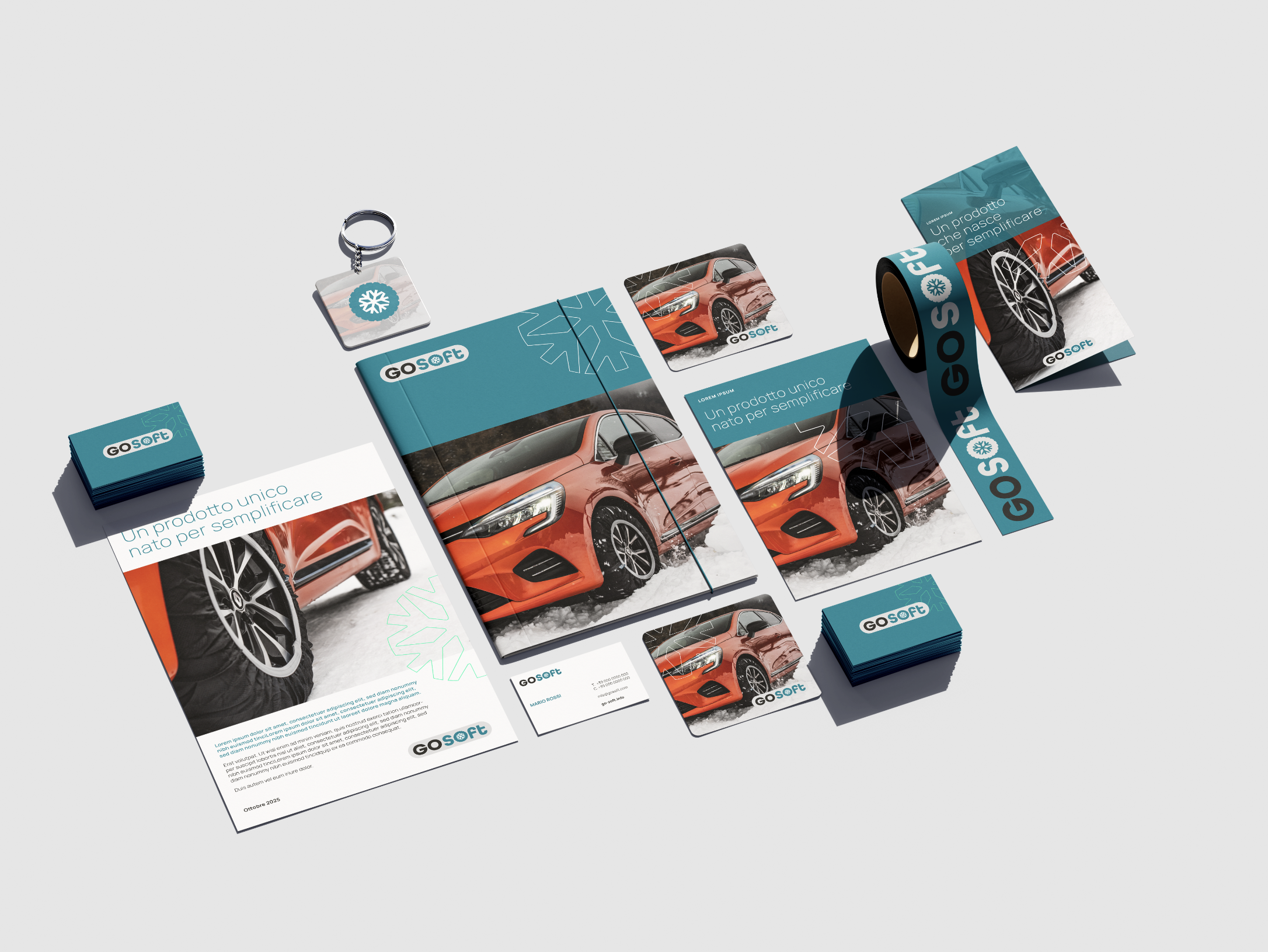 Materiali di branding per un'azienda chiamata GO SOFT, inclusi volantini, biglietti da visita, adesivi, distintivi e biglietti. I materiali mostrano un'auto sportiva arancione con neve sullo sfondo e presentano il logo e slogan dell'azienda in italiano.