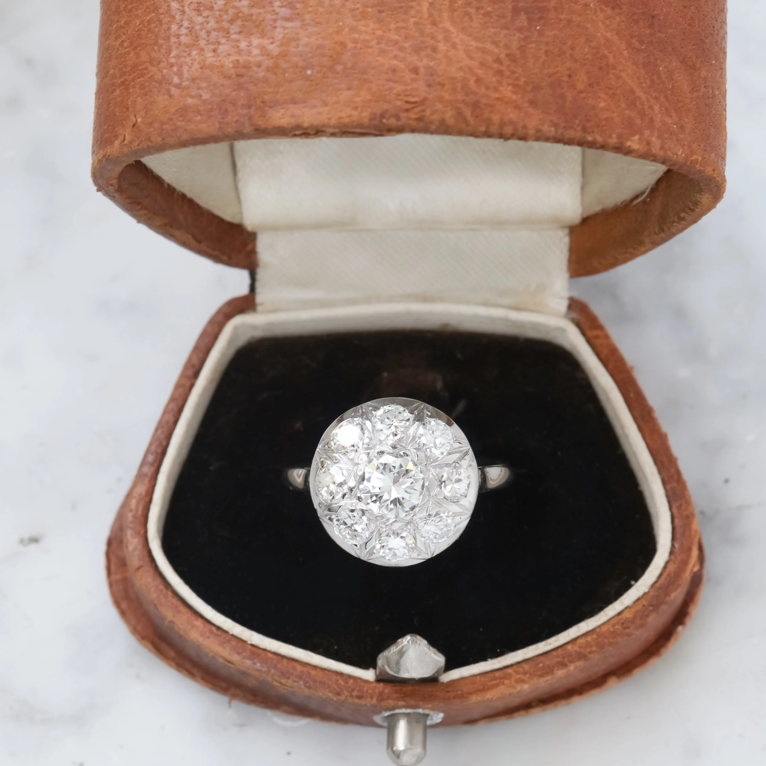 Bague en diamant dans une boîte de jewelry vintage en cuir marron, le fond intérieur est en velours noir