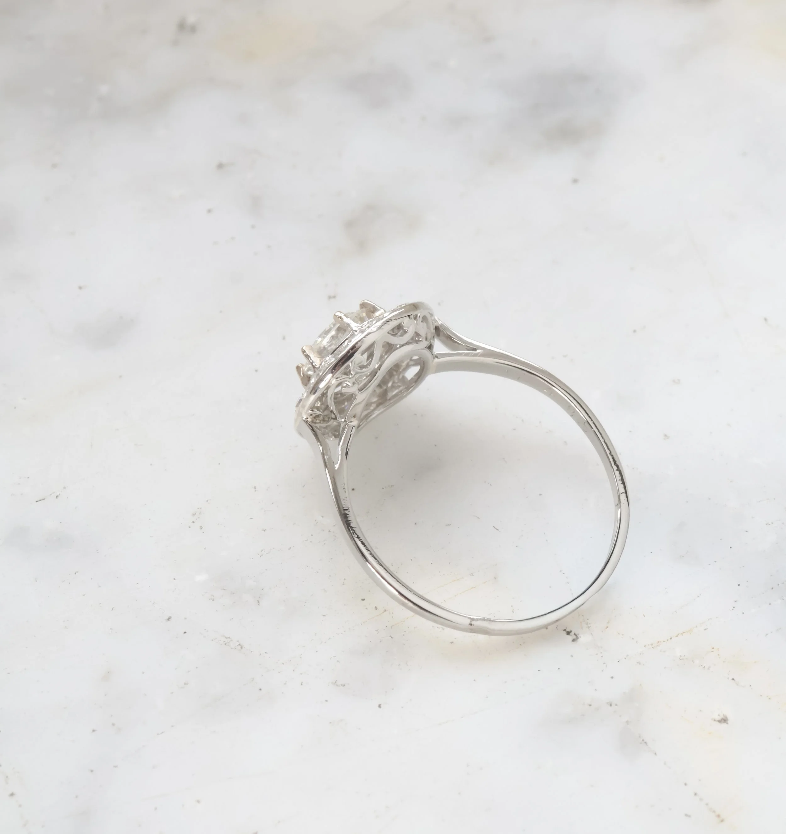 Bague en argent avec une pierre précieuse transparente, posée sur une surface blanche.