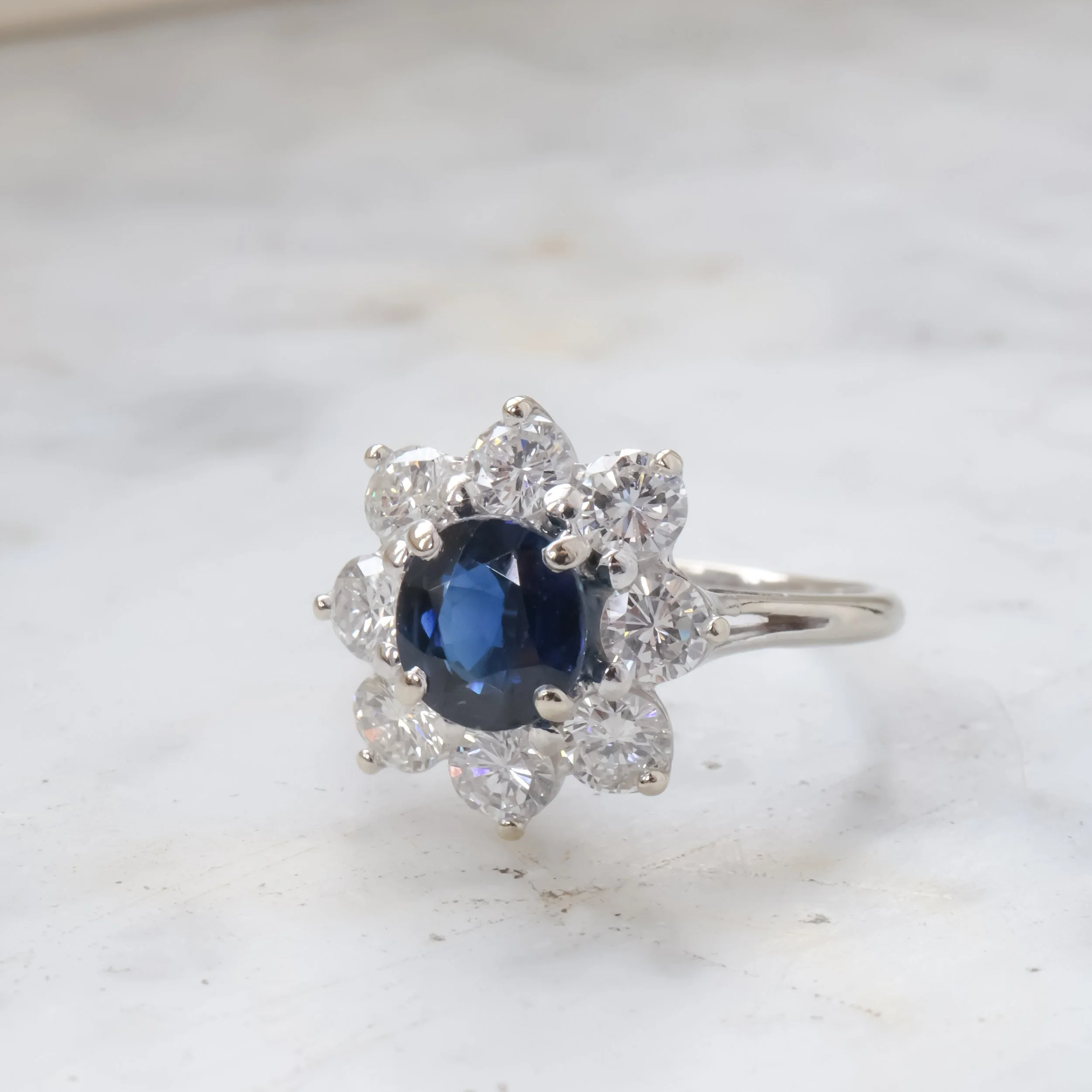 Bague en argent avec un saphir bleu au centre entouré de diamants