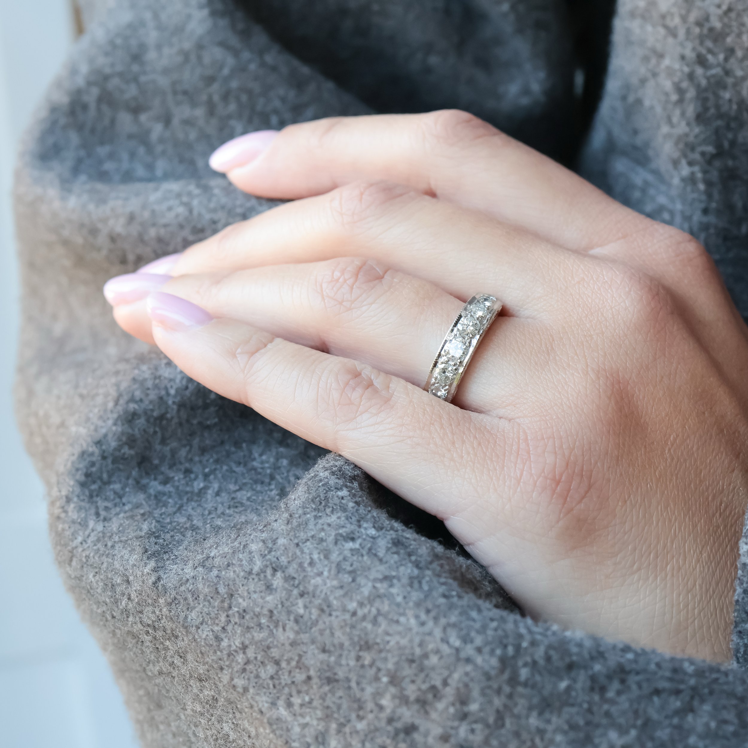 Une demi alliance ancienne art déco ornée de diamants portée a la main 