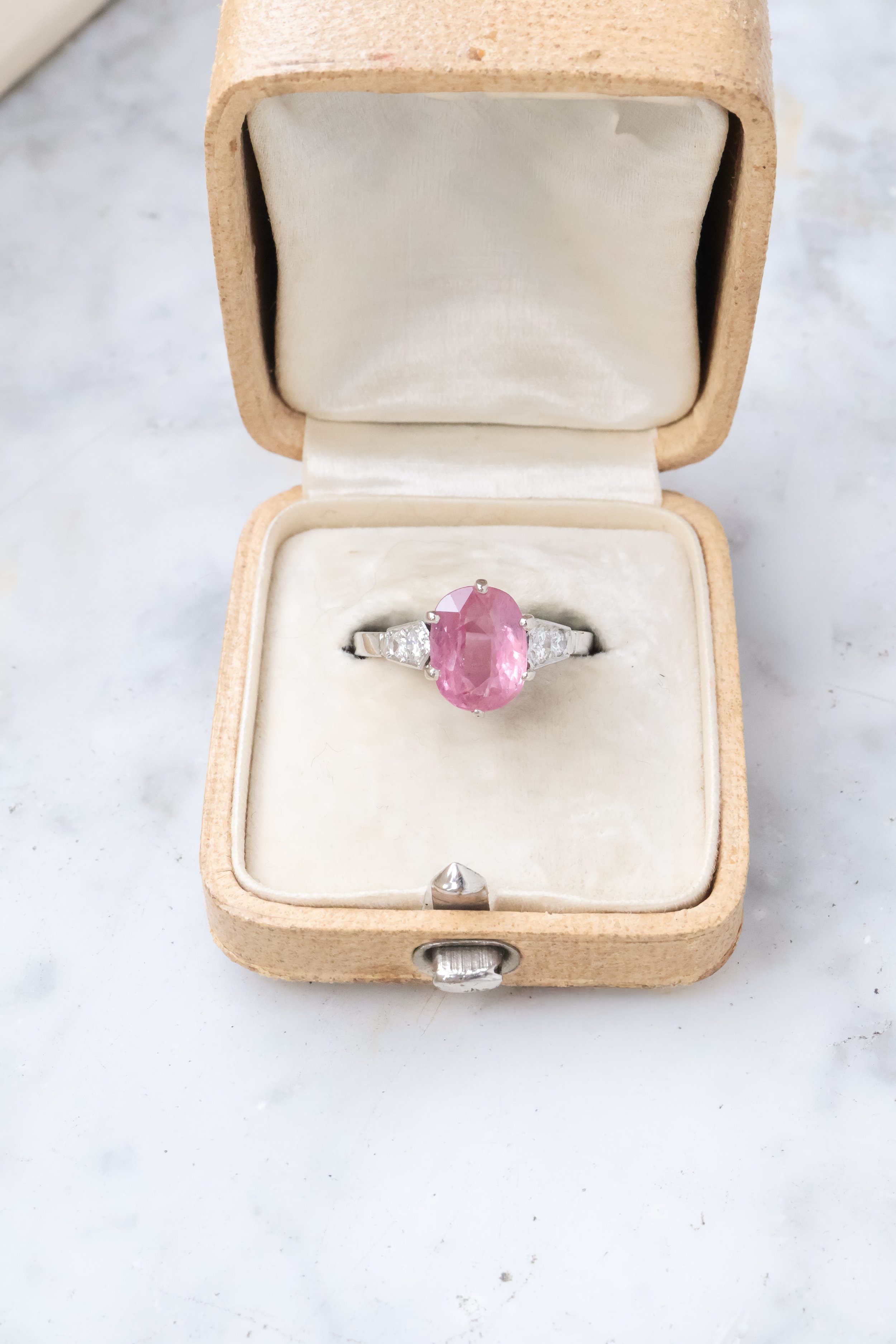 Bague en or ornée d'un saphir rose et de diamants dans un écrin ancien