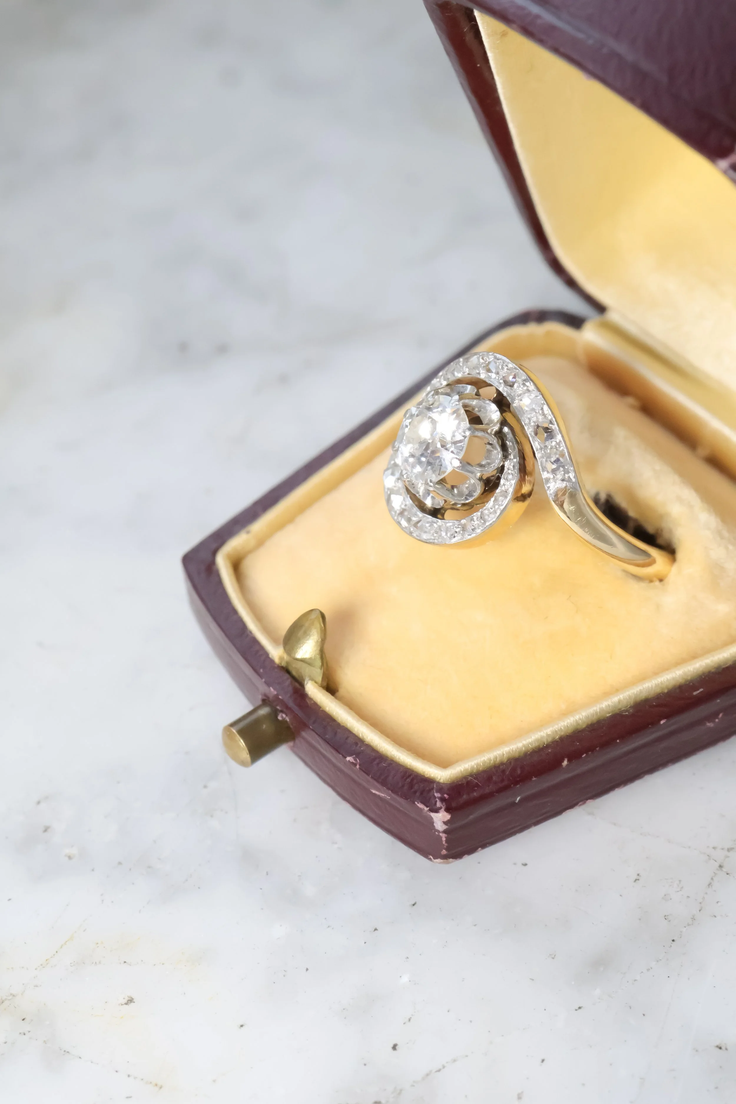 Bague ancienne en or ornée de diamants, présentée dans un écrin ancien en bois, vue de profil