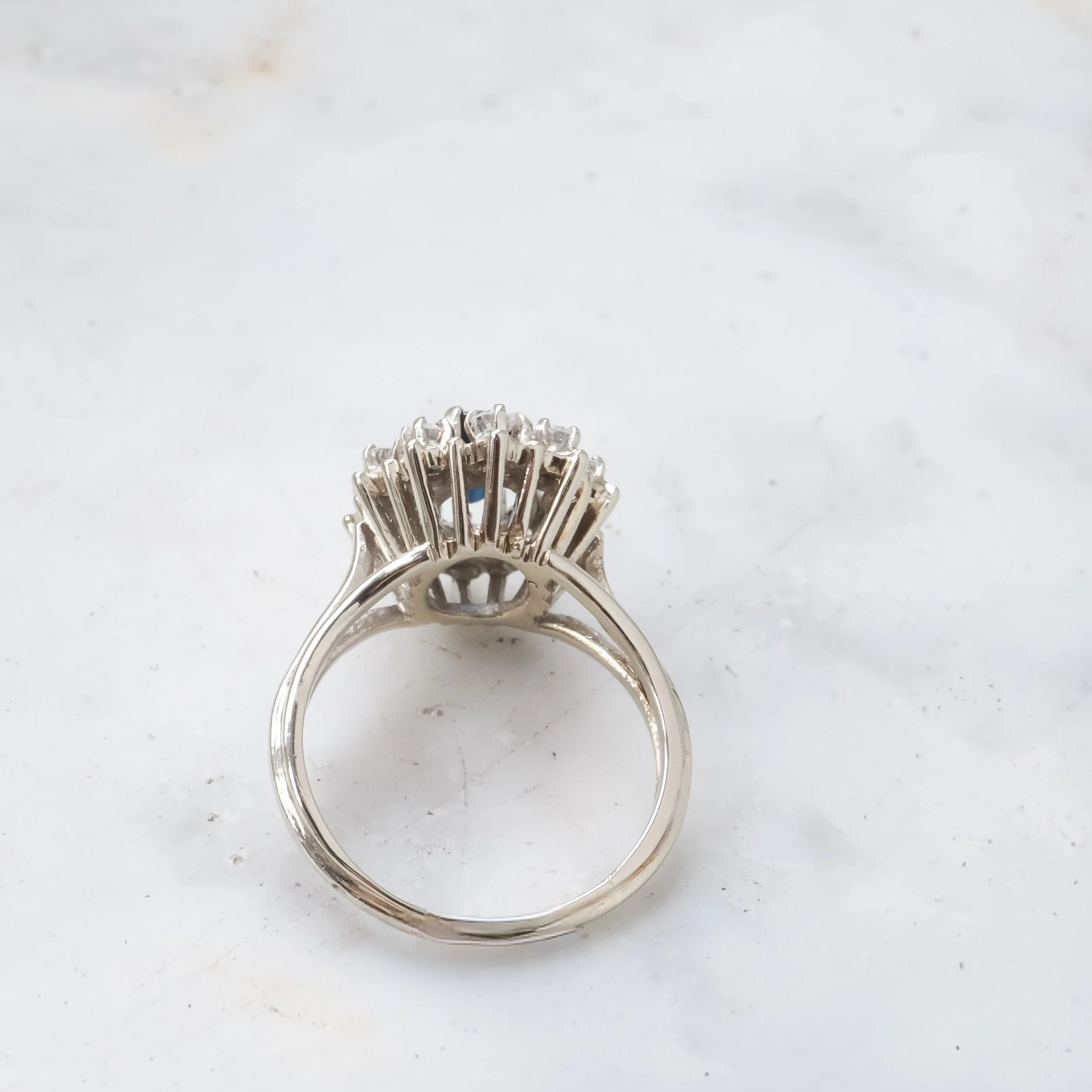 Bague en métal avec une rangée de pierres précieuses ou diamants visibles de dessus.