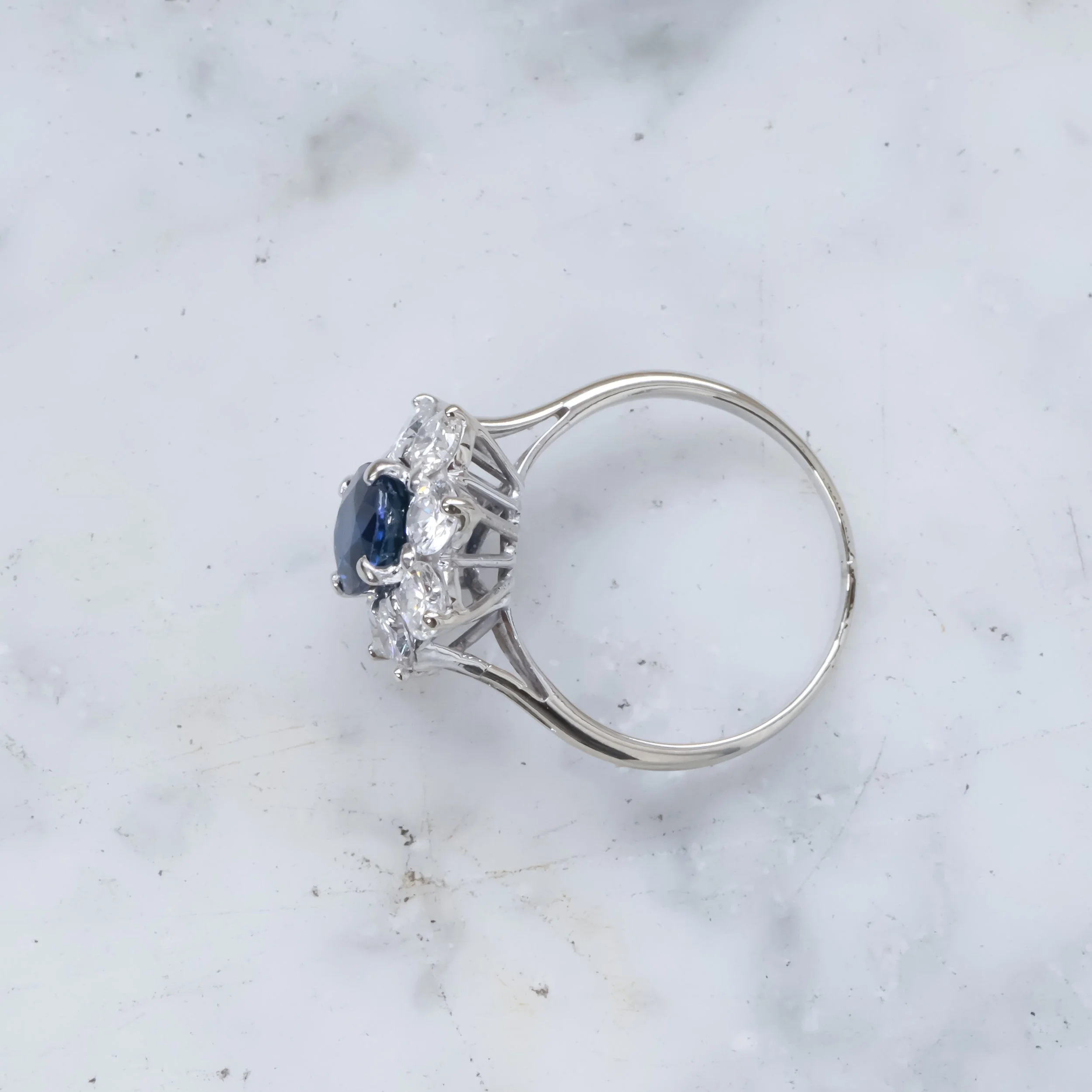 Bague en argent avec une pierre centrale bleue entourée de diamants