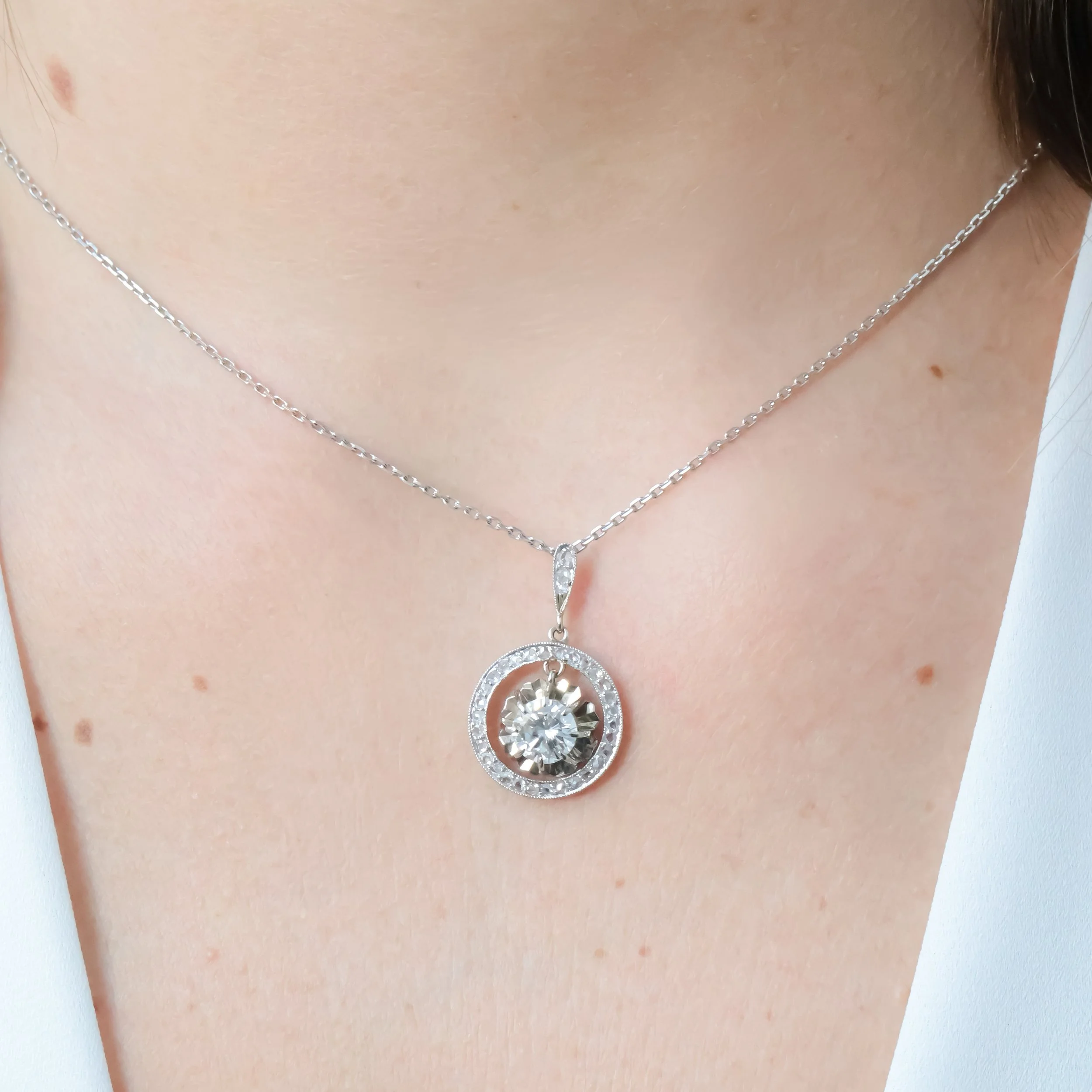 Collier en argent avec pendentif rond orné de diamants.