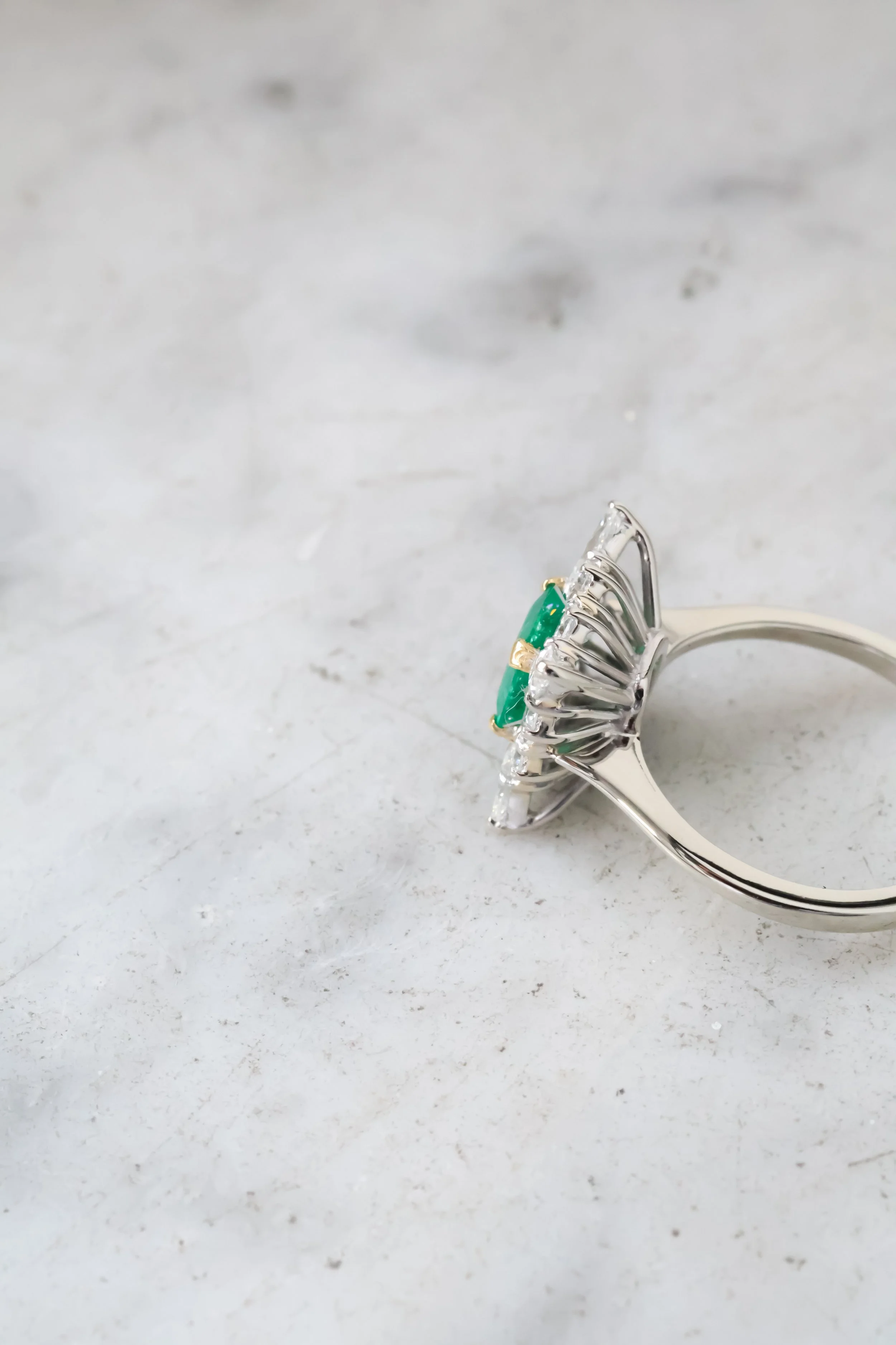 Bague ancienne en or blanc, émeraude centrale et diamants, vue de profil
