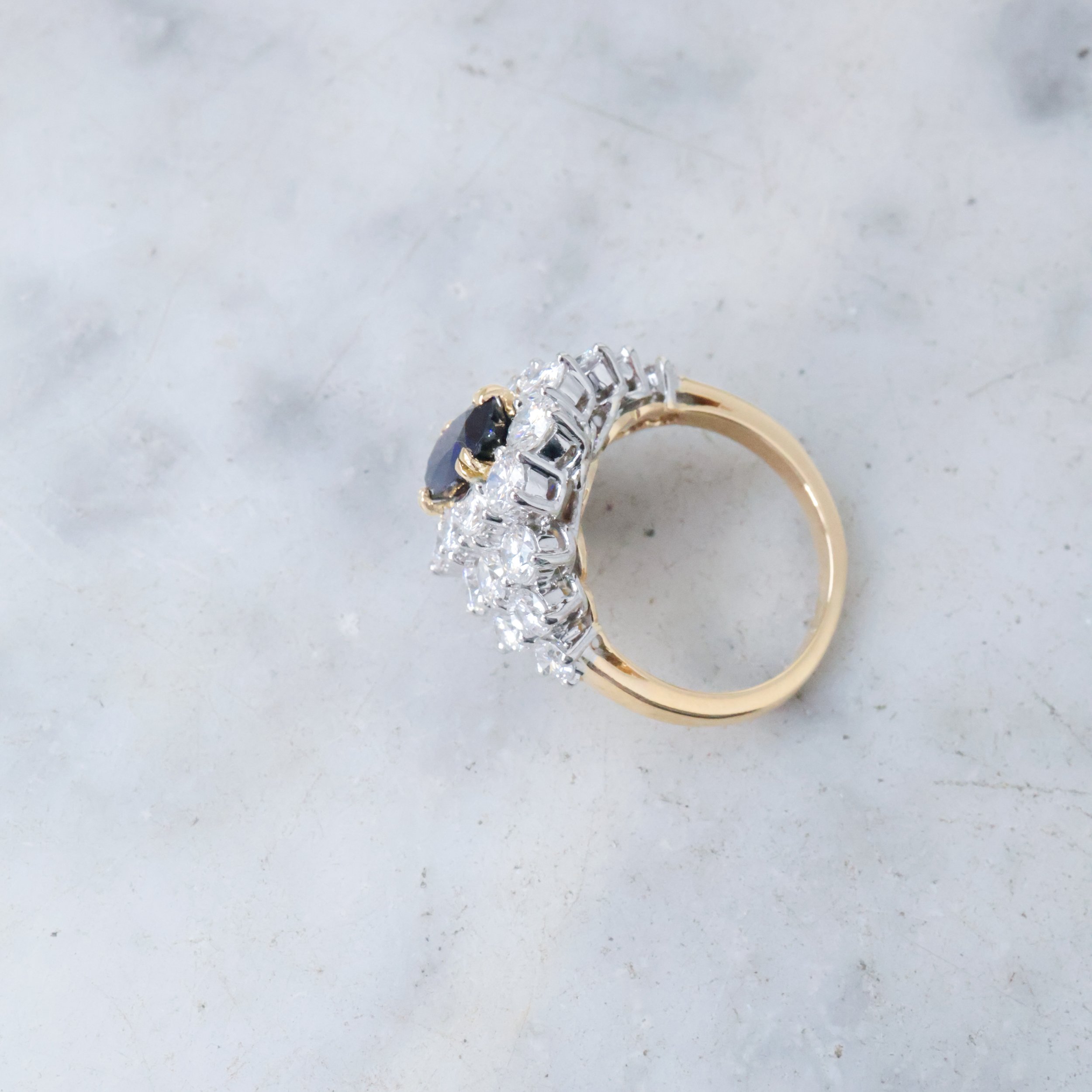 Bague en or avec des diamants noirs et blancs montée sur un fond gris clair