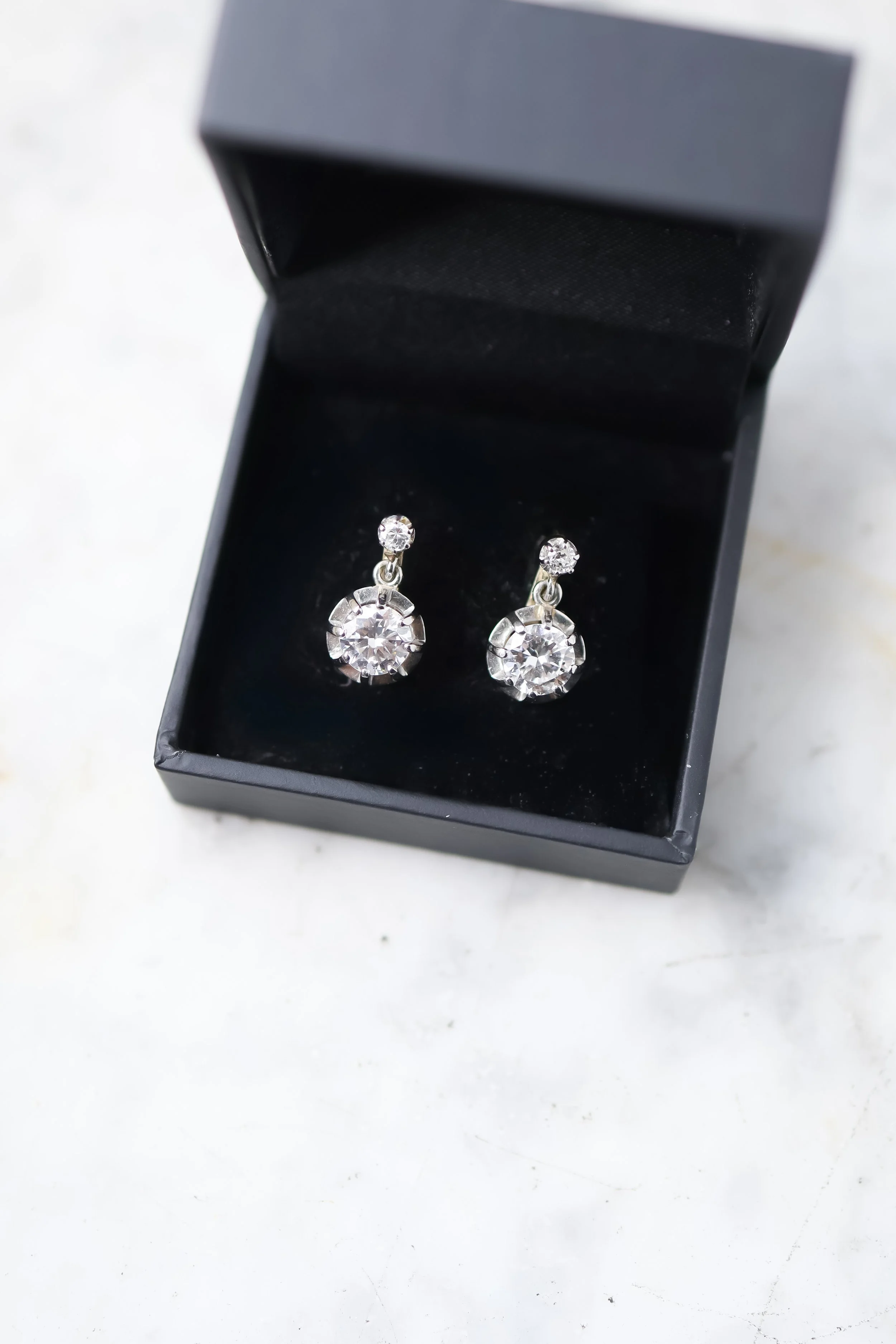 Boucles d'oreilles dormeuses  avec des diamants dans un écrin noir 