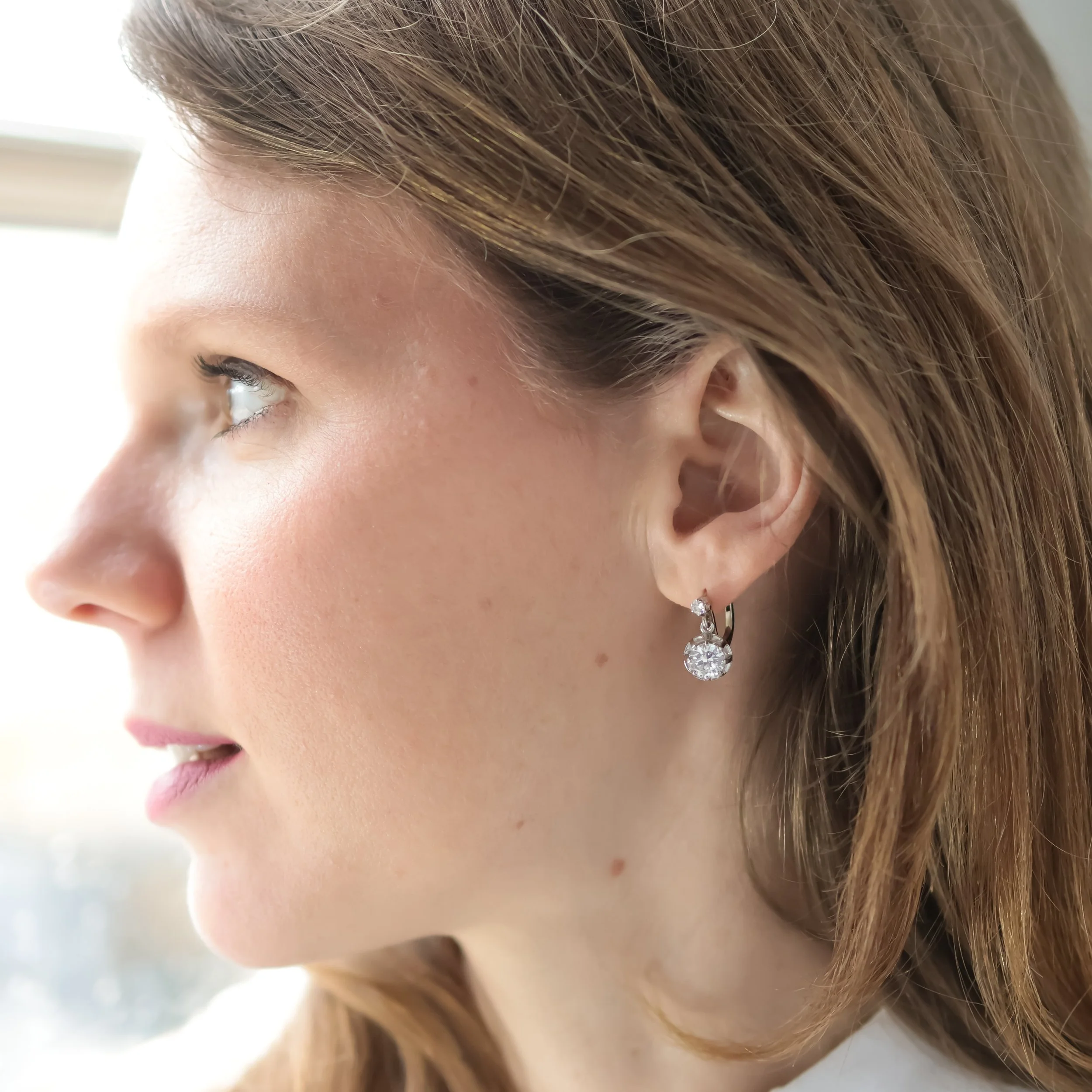 Focus d'une femme portant des boucles d'oreilles en diamants.