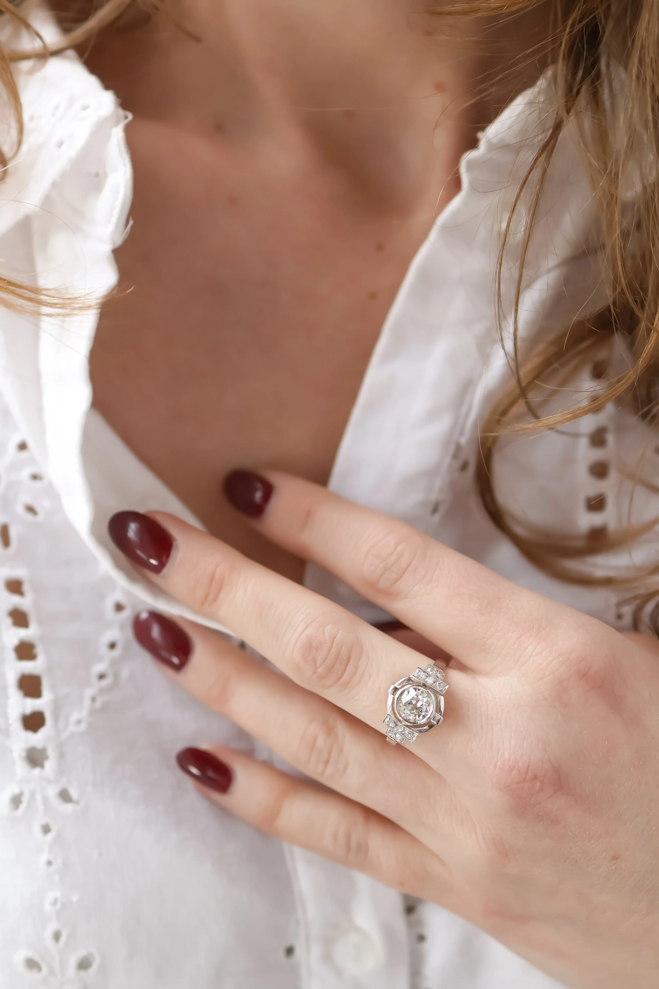 Gros plan sur une main portant une bague art déco avec des diamants 