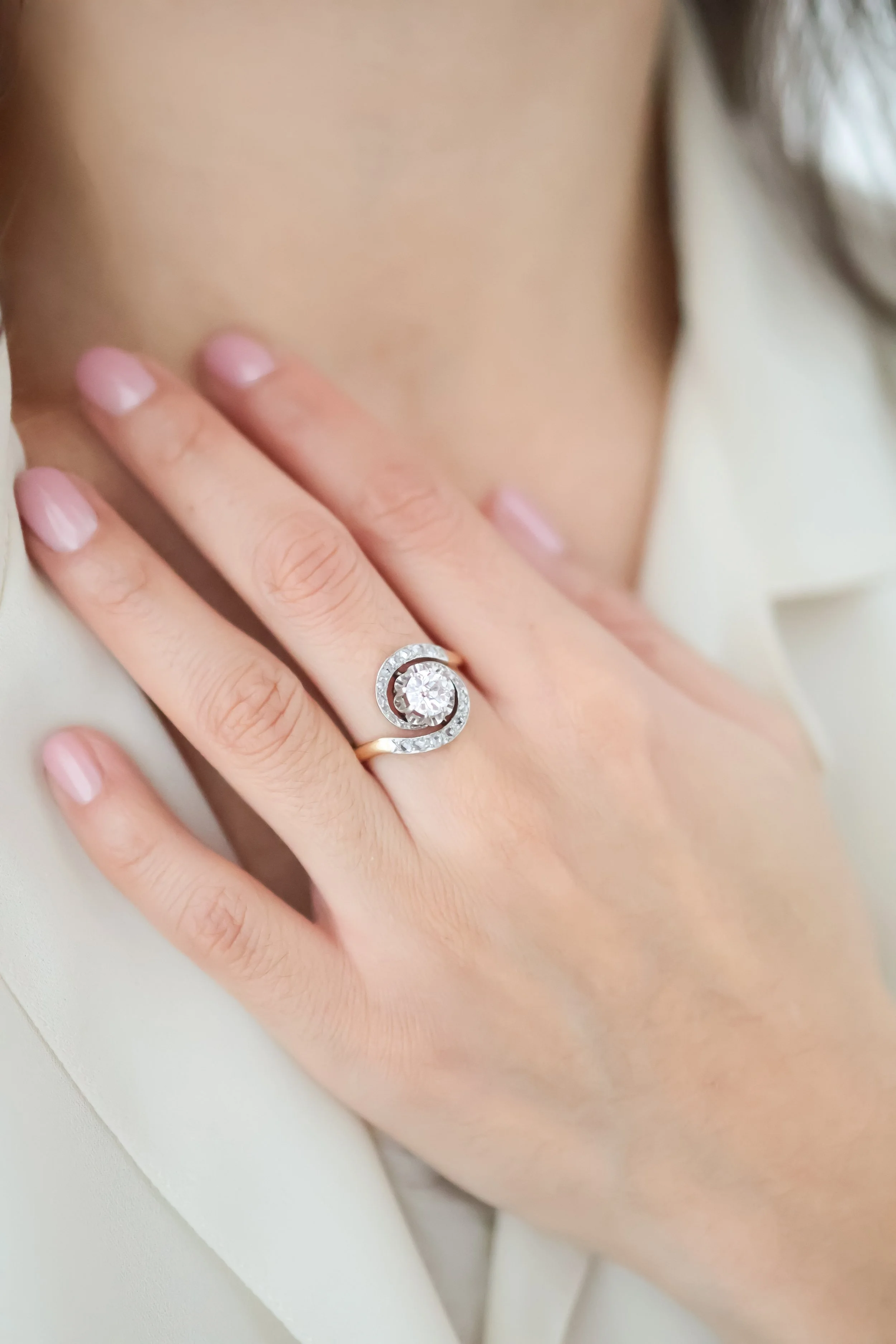 Bague ancienne tourbillon en or ornée de diamants, portée à la main 