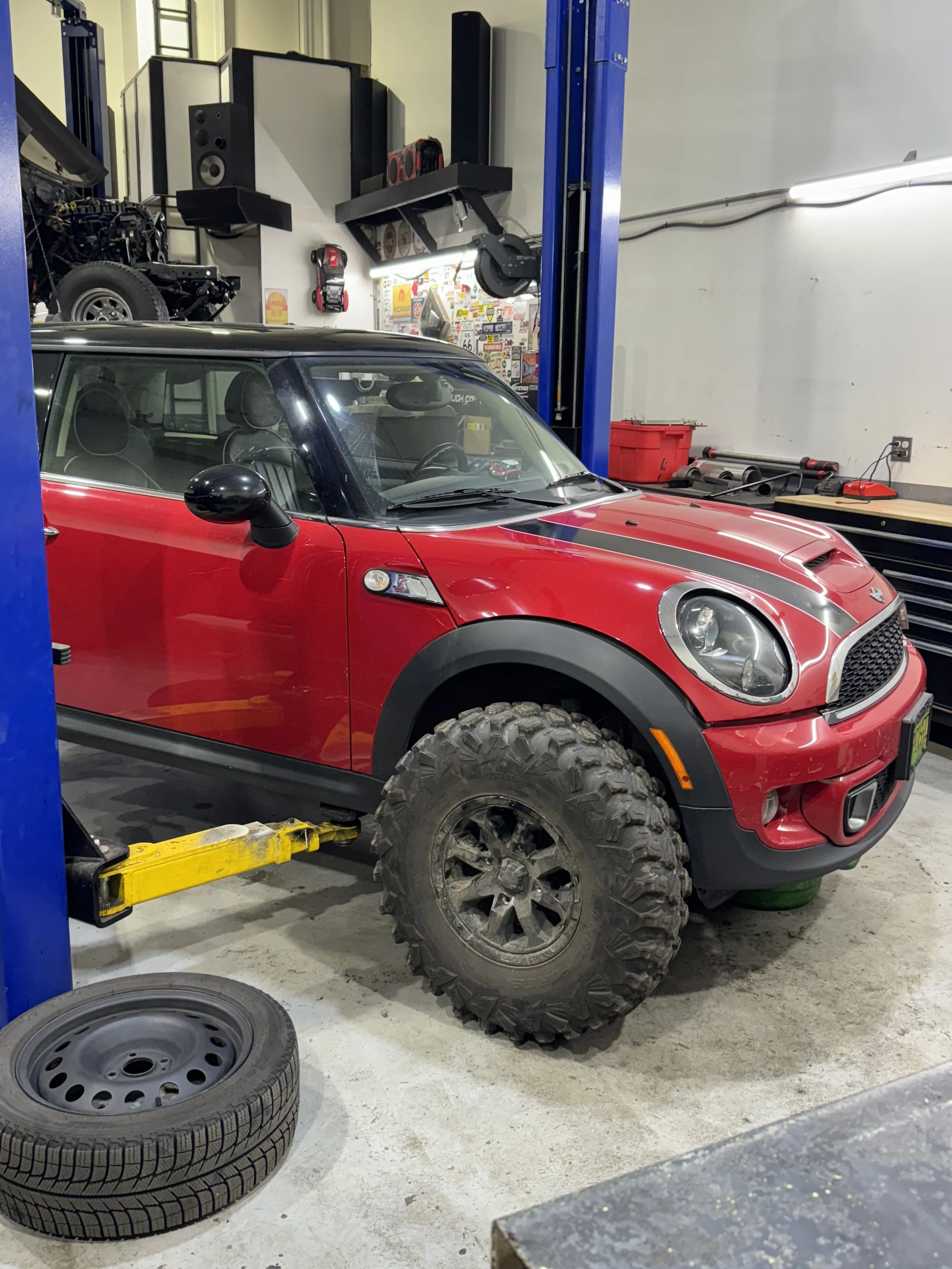 Lifted Mini Cooper with oversized off-road tires, custom suspension, and rugged modifications designed for off-road driving