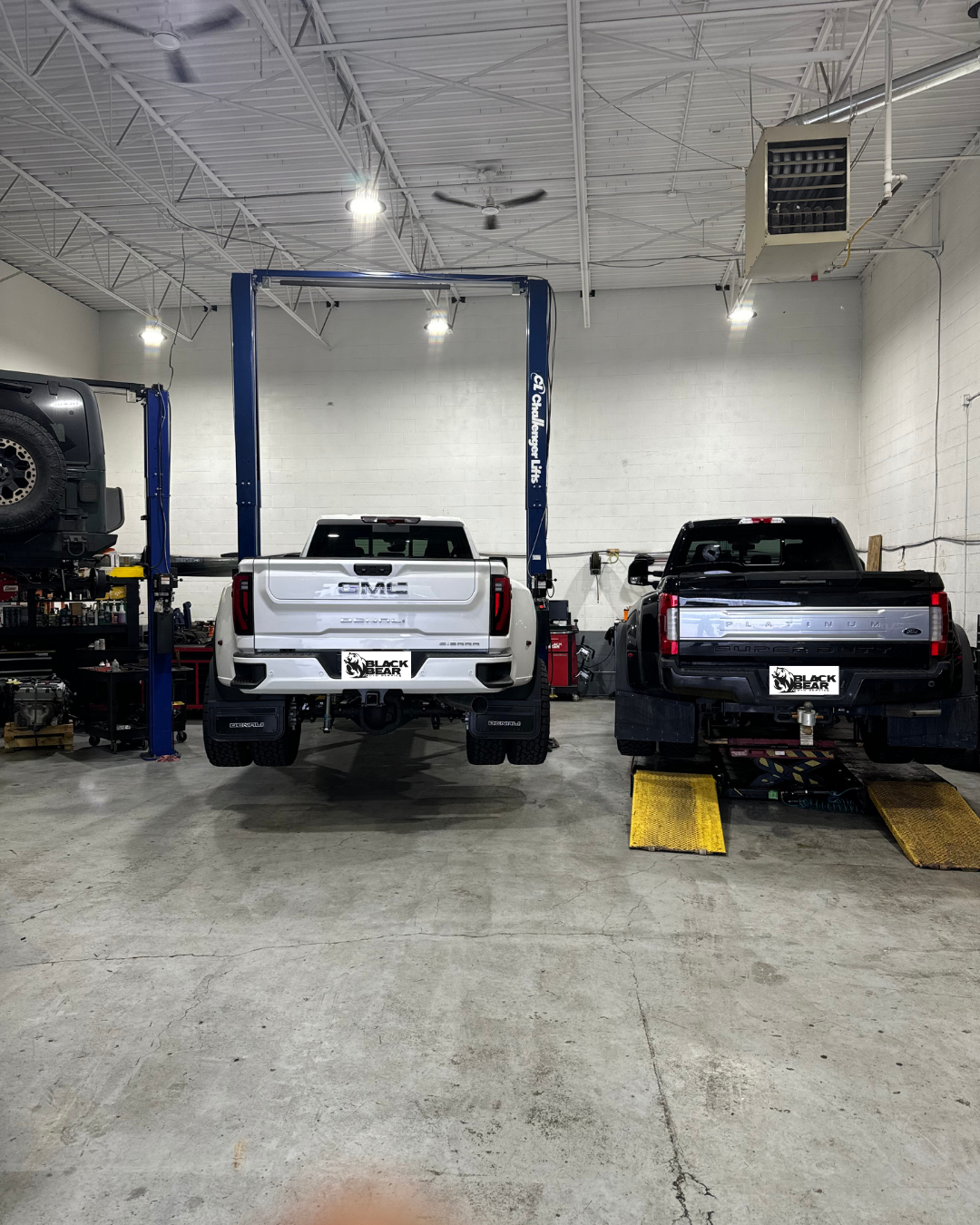 GMC and Ford truck getting service at Black Bear Auto Service