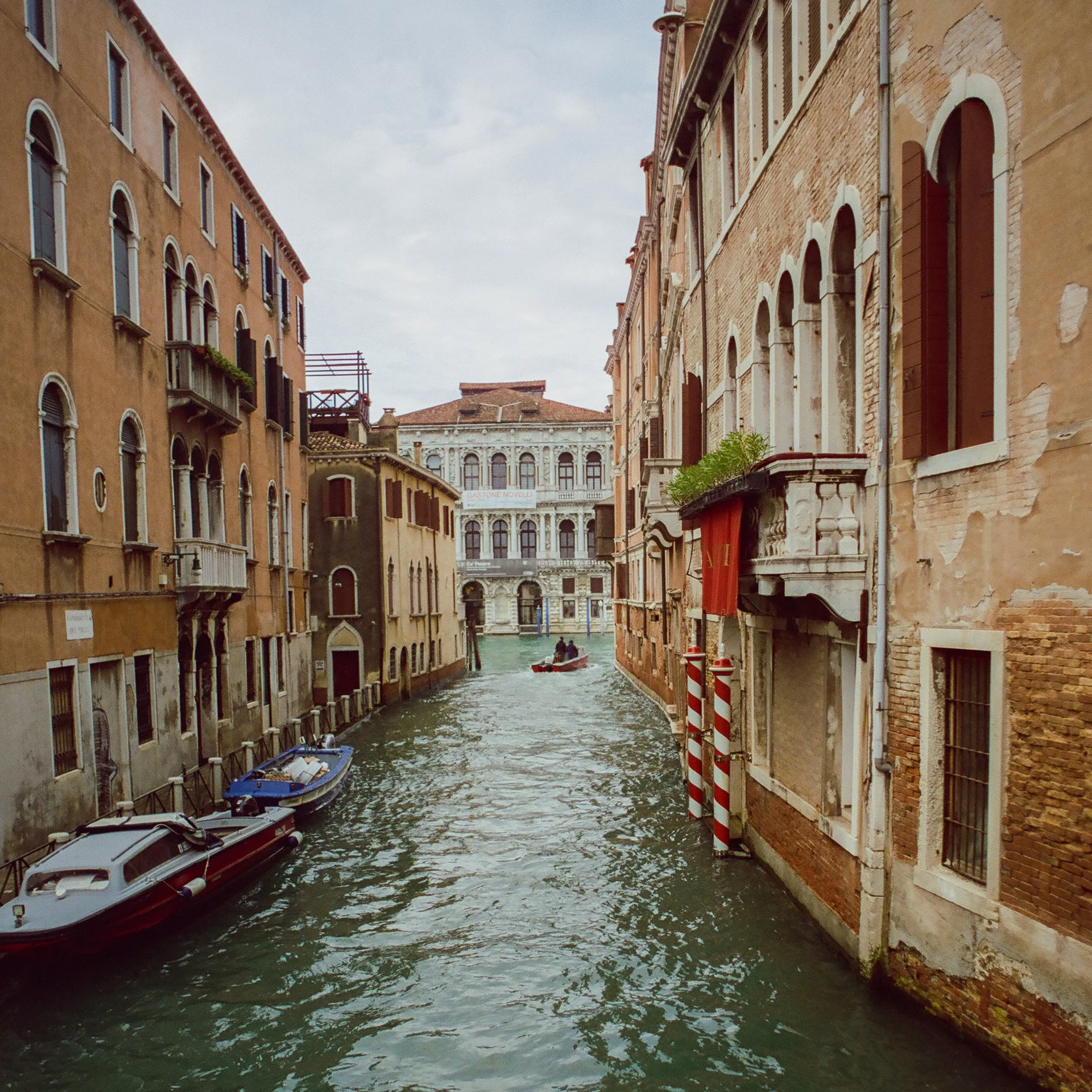 Venetian canal with boats and historic buildings on either side