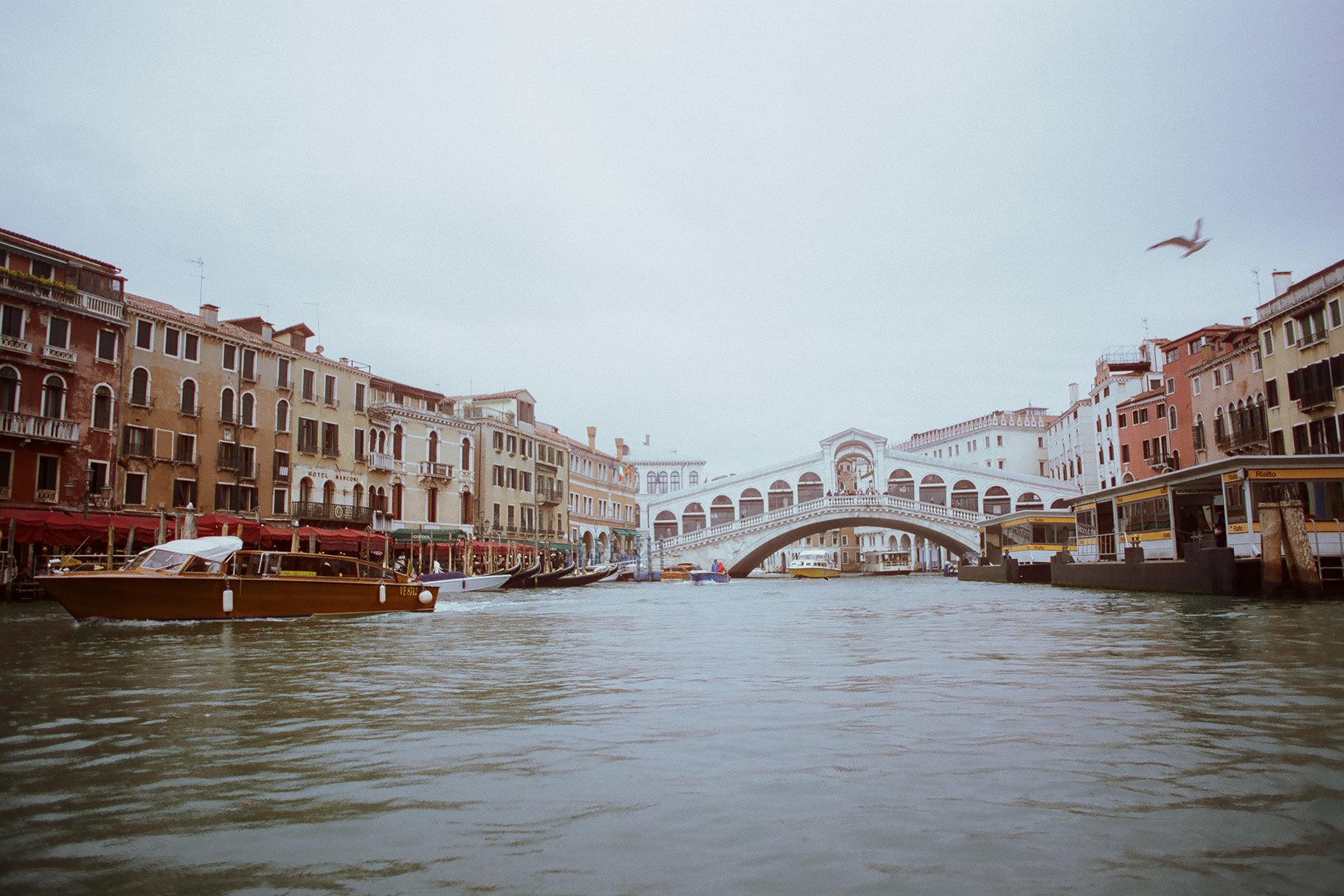 Venetian canal with boats, colorful buildings, and a bridge