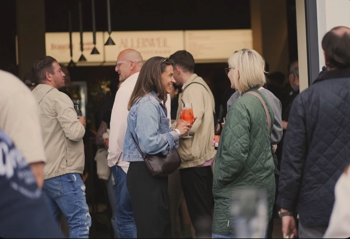 Menschen, die auf einer Party oder Veranstaltung Getränke in der Hand halten, sprechen und lachen miteinander.
