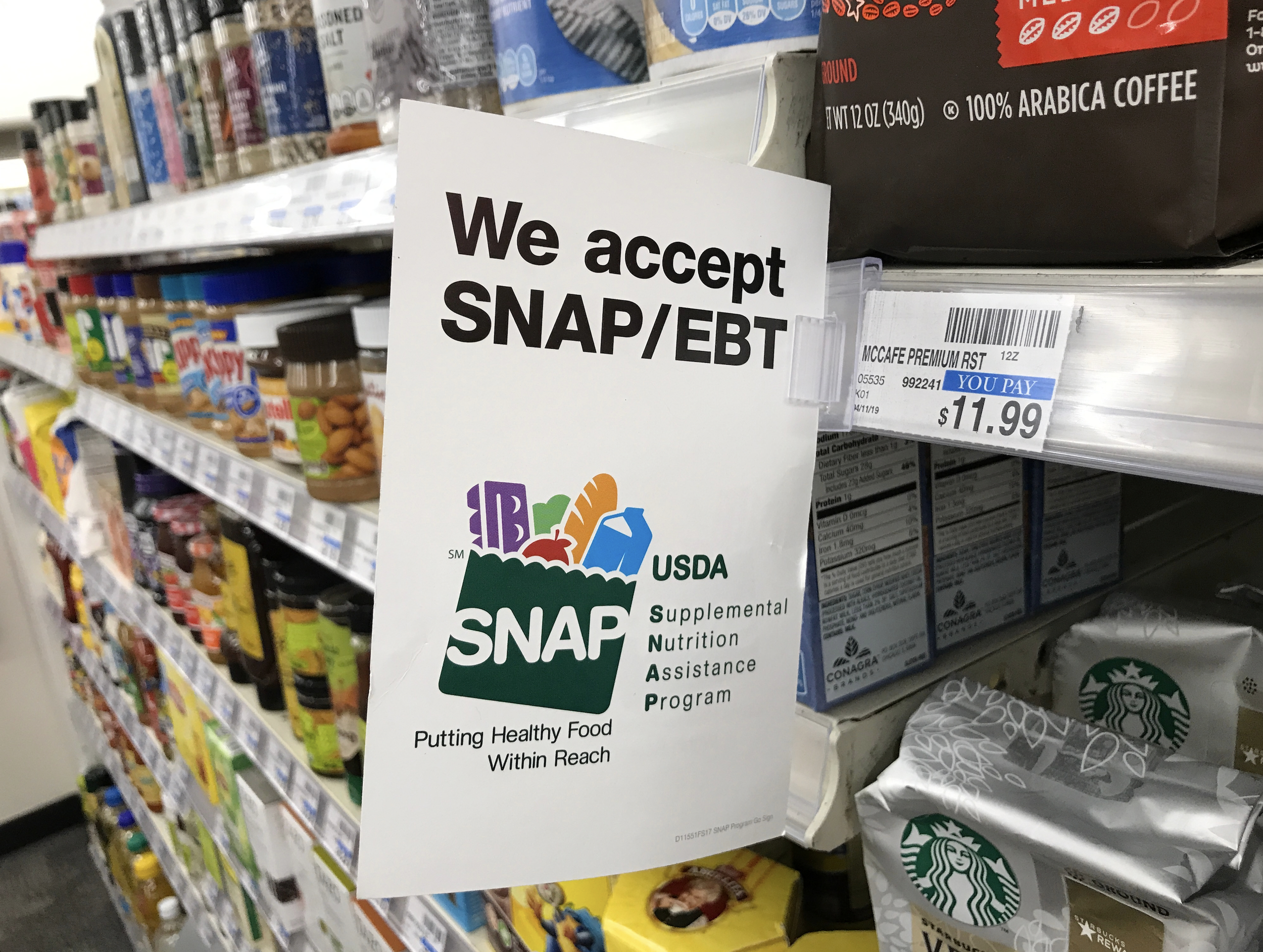 Shelf with various food products and a sign that says, "We accept SNAP/EBT."