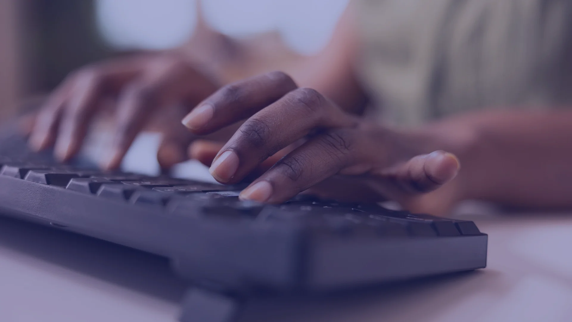 Close-up of a person's hand typing on a computer keyboard.