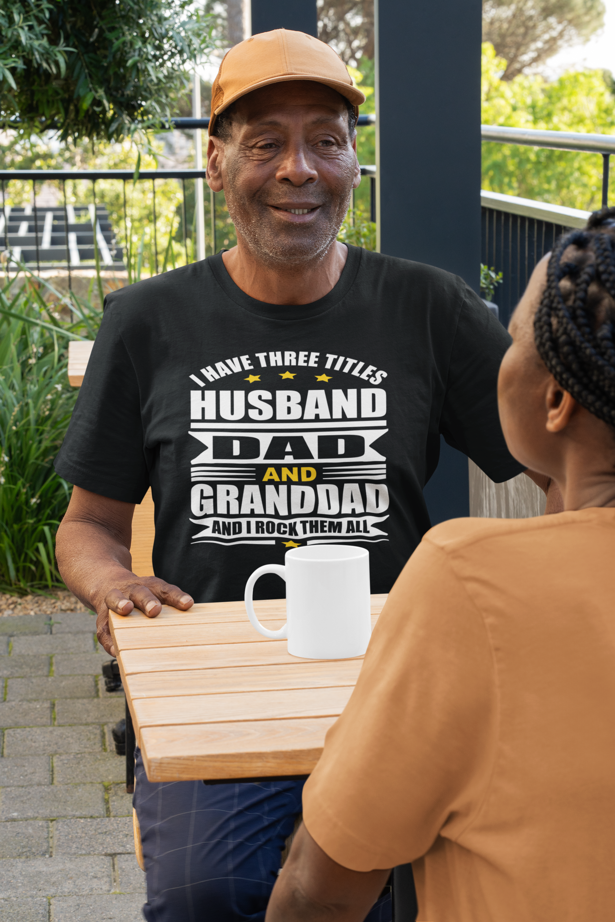 t-shirt-and-coffee-mug-mockup-of-an-elderly-man-talking-with-his-wife-at-a-restaurant-m51505.png