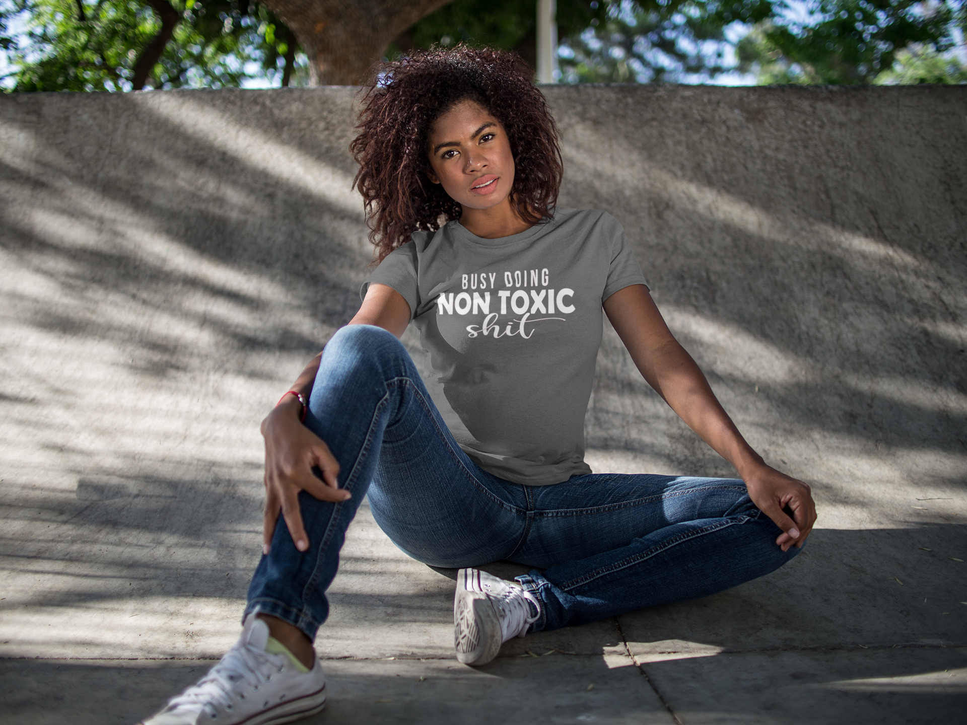 mockup-of-a-woman-wearing-a-round-neck-t-shirt-while-sitting-down-outdoors-15807.png
