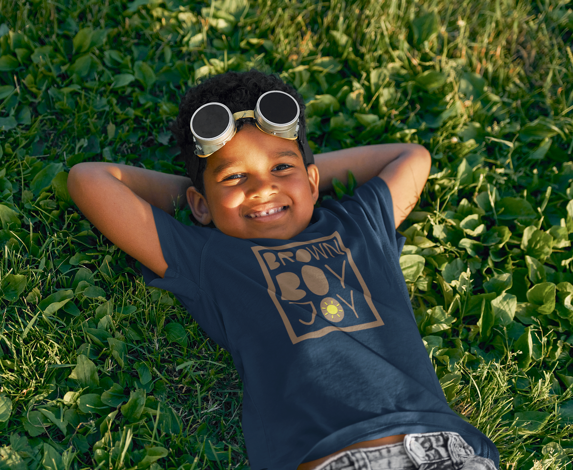t-shirt-mockup-of-a-smiling-boy-laying-on-the-grass-with-toy-plane-glasses-m17007-r-el2 (1).png