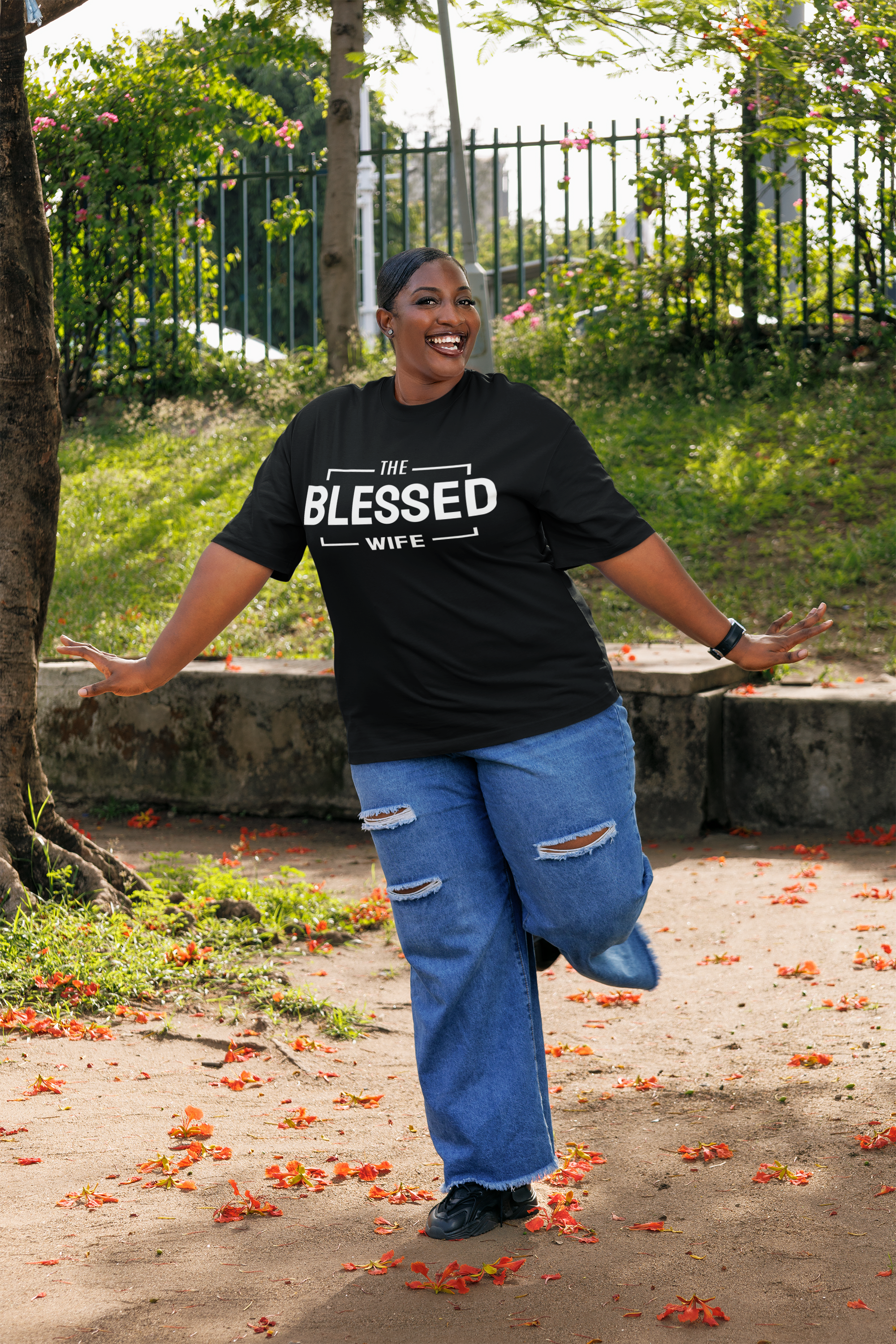 oversized-t-shirt-mockup-of-a-cheerful-woman-in-jeans-posing-in-a-park-m56945.png