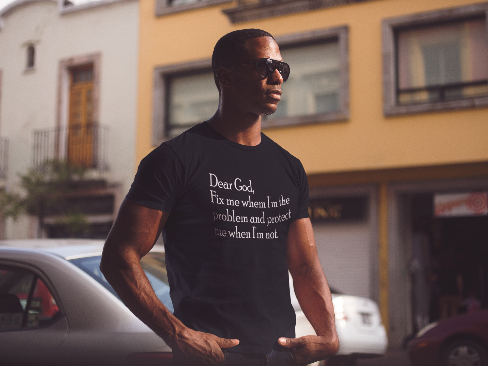 young-black-man-wearing-a-short-sleeved-round-neck-t-shirt-and-sunglasses-while-staring-at-the-city-mockup-a14220.png