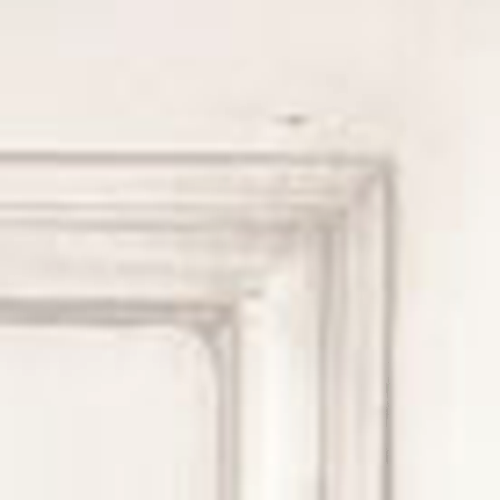 Close-up of a white fireplace mantel against a white wall.