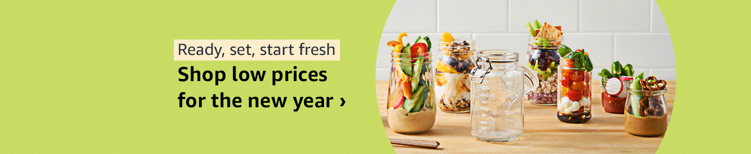 Several jars with colorful salads and toppings on a wooden surface, against a white tiled wall.