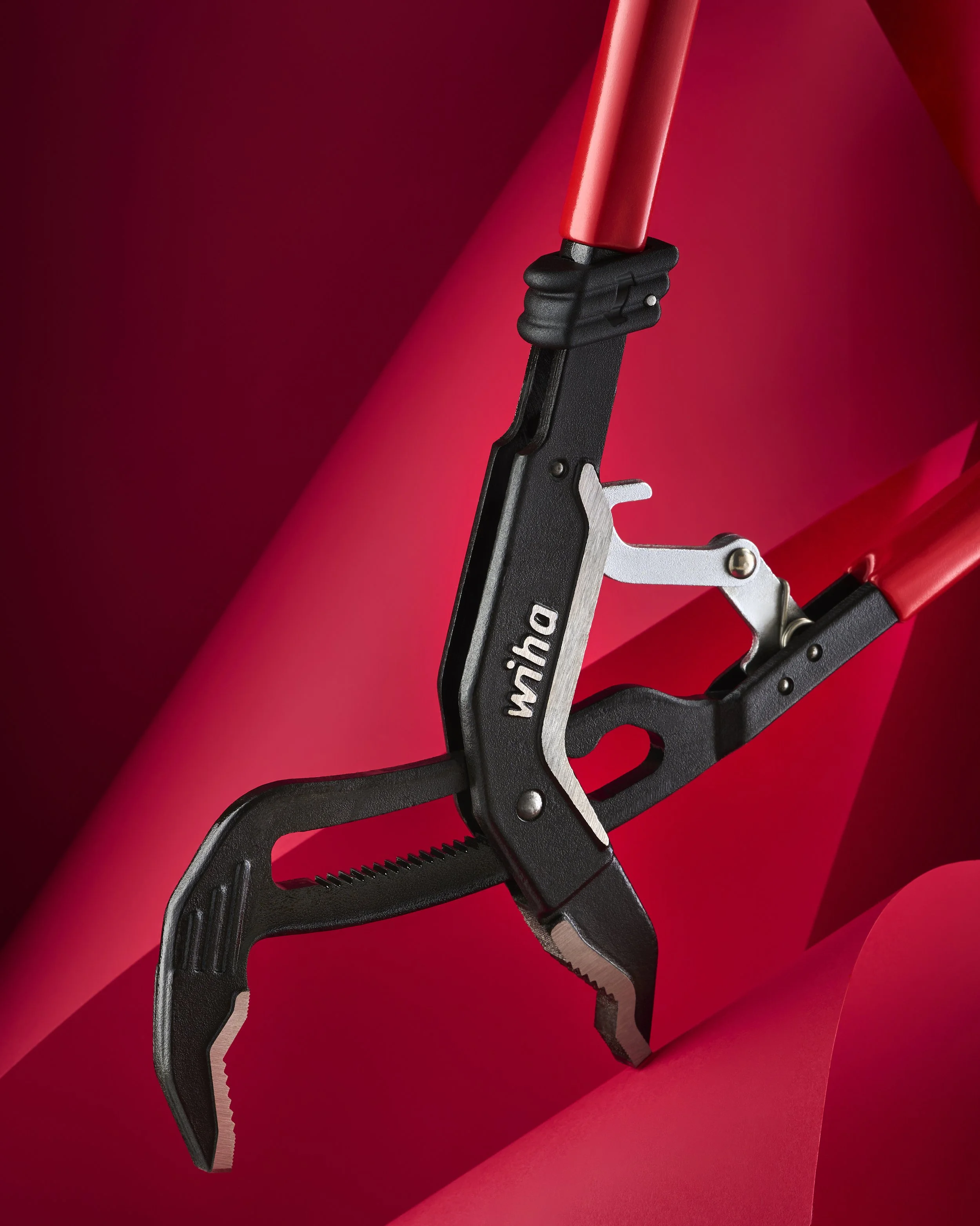 A multi-tool with pliers, a saw, and a knife, on a red background.