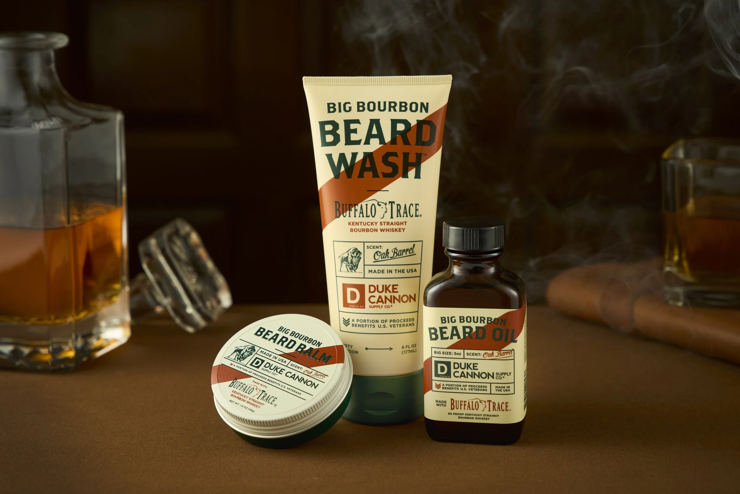 Collection of beard grooming products including beard wash, beard balm, and beard oil, all branded Buffalo Trace with Kentucky straight bourbon whiskey scent, displayed on a brown surface with a dark background.